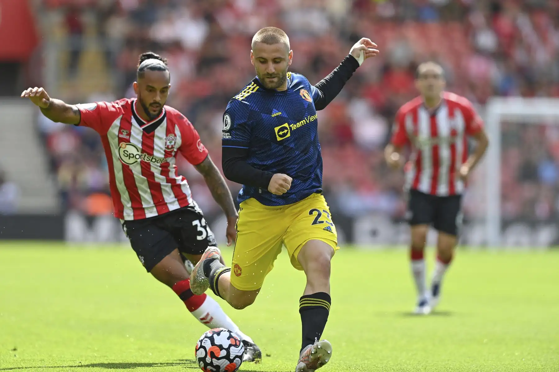 El defensor inglés del Manchester United Luke Shaw compite por el balón contra el mediocampista inglés de Southampton Theo Walcott durante partido por la Premier League, en el Saint Mary