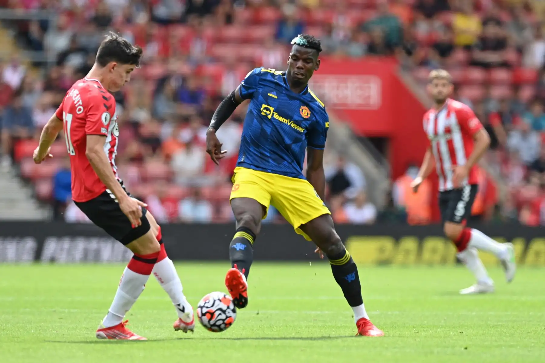 El defensor inglés de Southampton Tino Livramento compite por el balón contra el mediocampista francés del Manchester United Paul Pogba durante el partido de la Premier League, en el Saint Mary