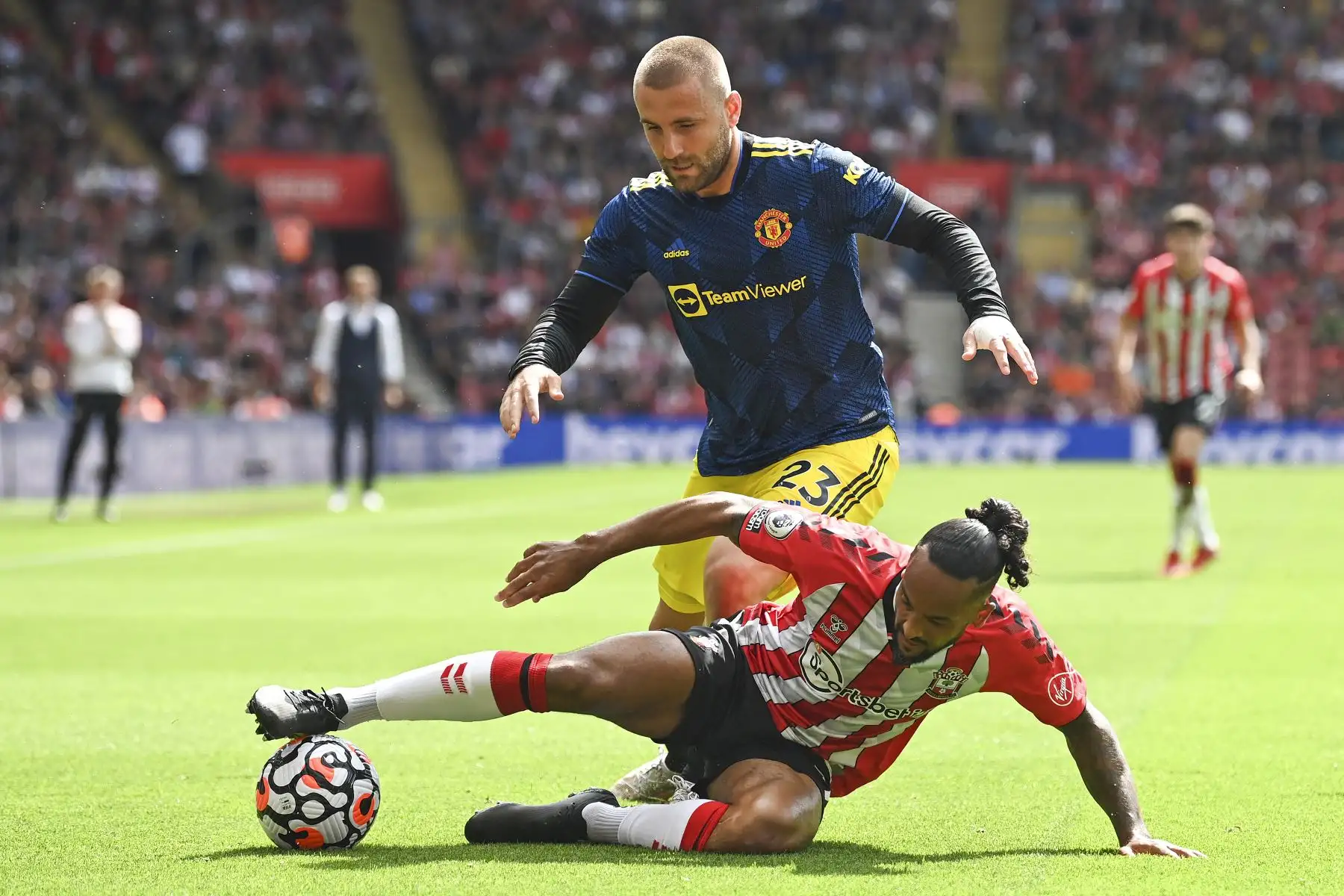 El defensor inglés del Manchester United Luke Shaw compite por el balón contra el mediocampista inglés de Southampton Theo Walcott durante el partido de fútbol de la Premier League, en el St Mary