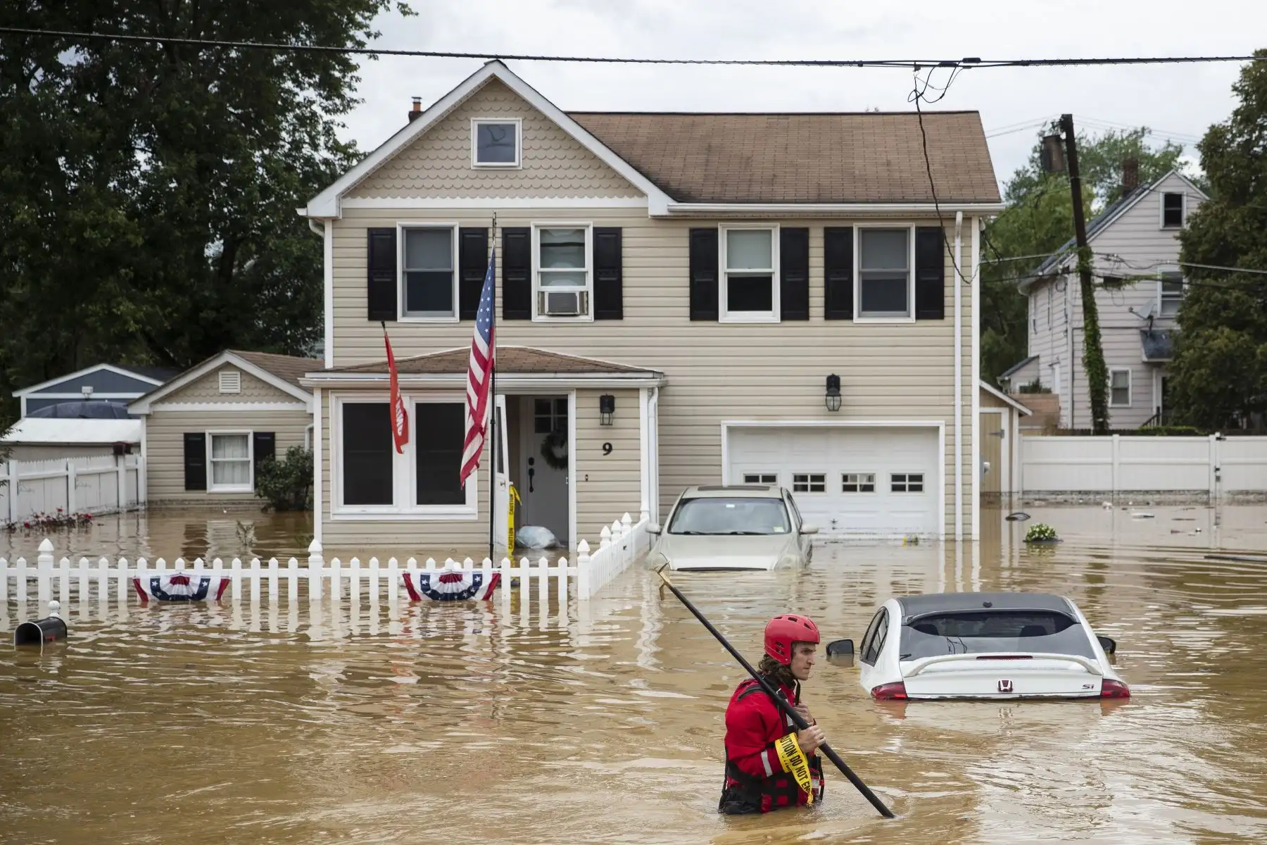 Un miembro de la tripulación de rescate de New Market Volunteer Fire Company atraviesa una zona residencial completamente inundada tras el paso de la tormenta tropical Henri, en Hemetta, Nueva Jersey, en los Estados Unidos. Foto: AFP