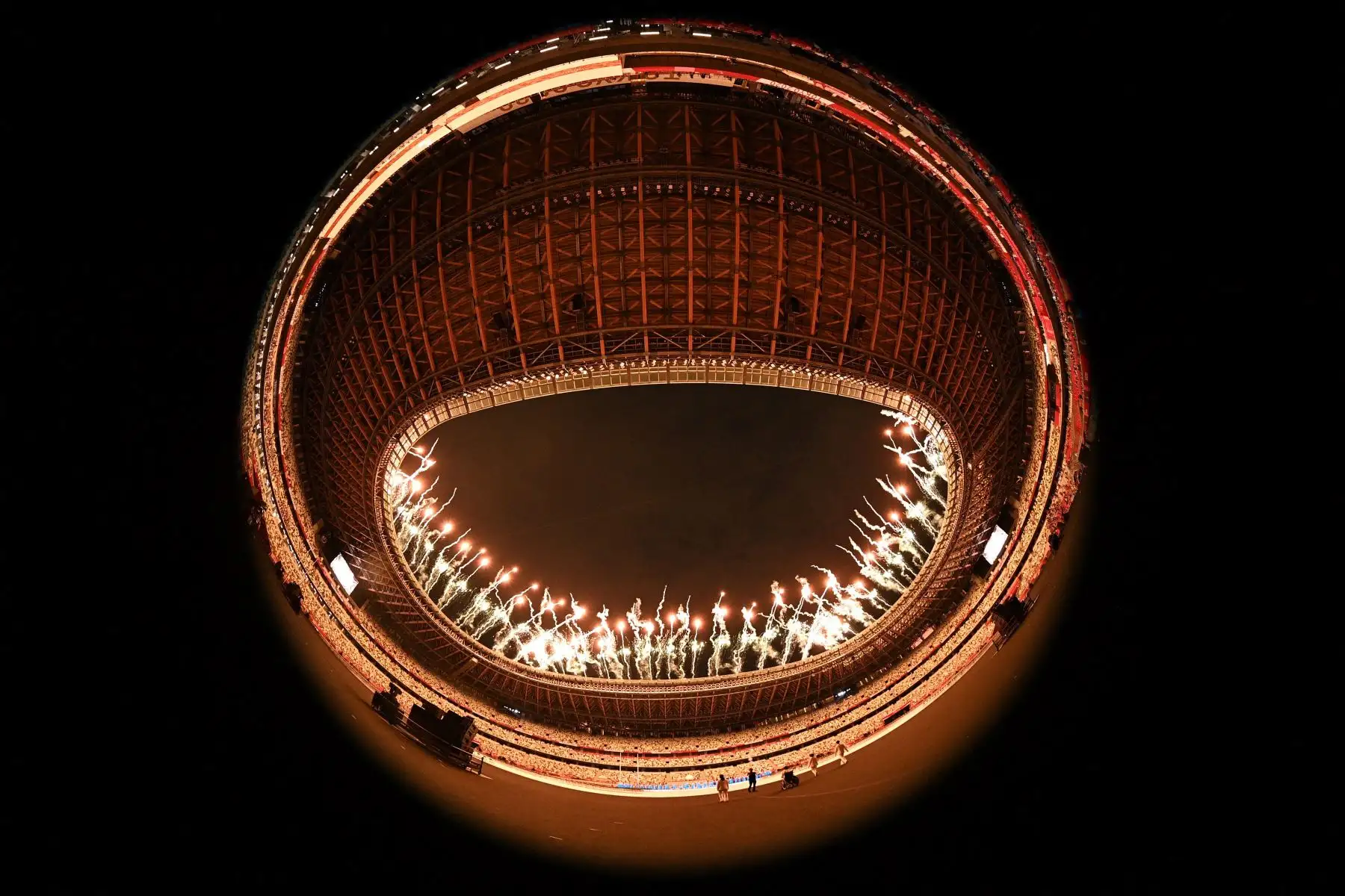 Esta imagen de ojo de pez muestra fuegos artificiales iluminando el cielo al comienzo de la ceremonia de apertura de los Juegos Paralímpicos de Tokio 2020 en el Estadio Olímpico de Tokio

Foto: AFP