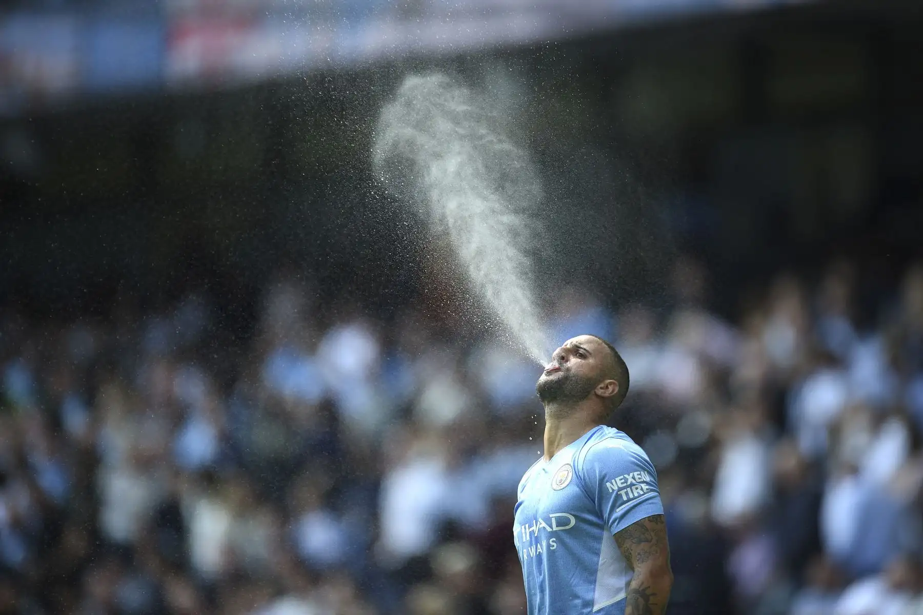 El defensa inglés del Manchester City, Kyle Walker, rocía agua antes del partido de fútbol de la Premier League. Foto: AFP