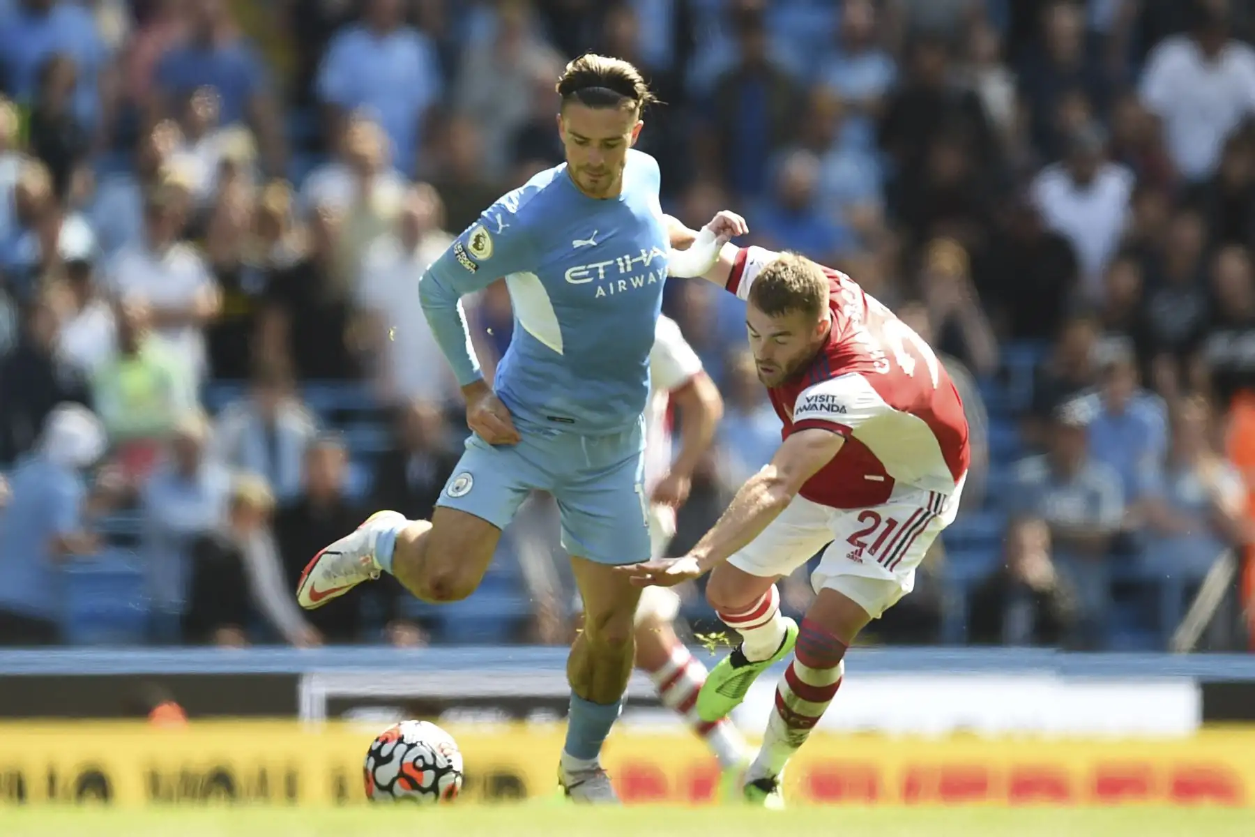 El centrocampista inglés del Manchester City, Jack Grealish, compite con el defensor inglés del Arsenal, Calum Chambers, durante el partido de la Premier League. Foto: AFP