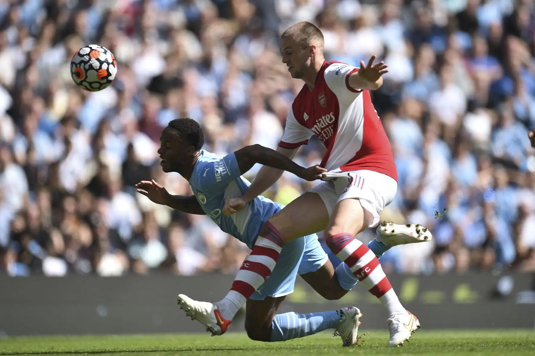 El centrocampista inglés del Manchester City Raheem Sterling compite con el defensor inglés del Arsenal Rob Holding durante el partido de fútbol de la Premier League. Foto: AFP