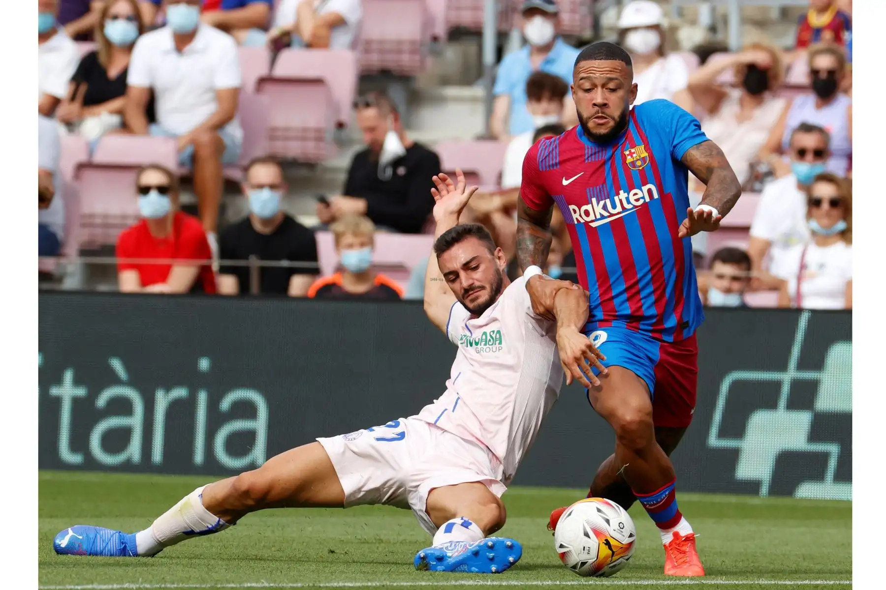 El delantero holandés del Barcelona Memphis Depay  pelea por el balón ante el lateral del Getafe Juan Iglesias durante el partido correspondiente a la tercera jornada de LaLiga Santander. Foto: EFE