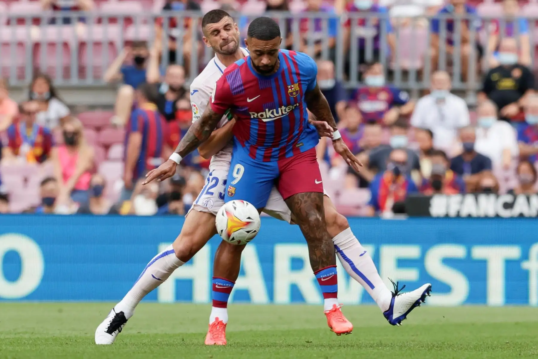 El delantero holandes del FC Barcelona Menphis Depay lucha con el centrocampista serbio del Getafe CF Stefan Mitrovic durante el partido de la tercera jornada de La Liga. Foto: EFE