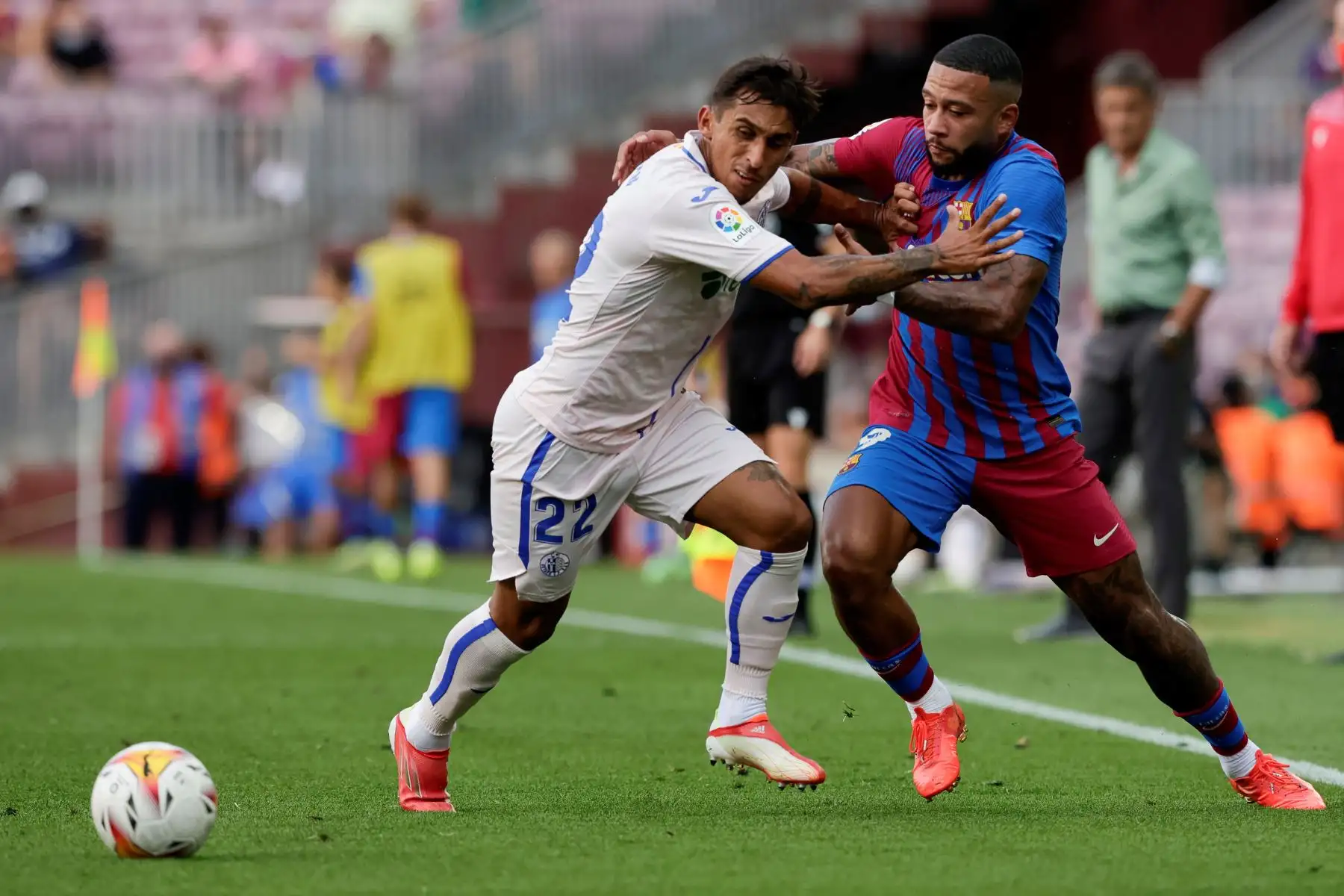 El delantero holandés del FC Barcelona Memphis Depay lucha con el delantero urugayo del Getafe CF Damián Suárez curante el partido de la tercera jornada de La Liga. Foto: EFE