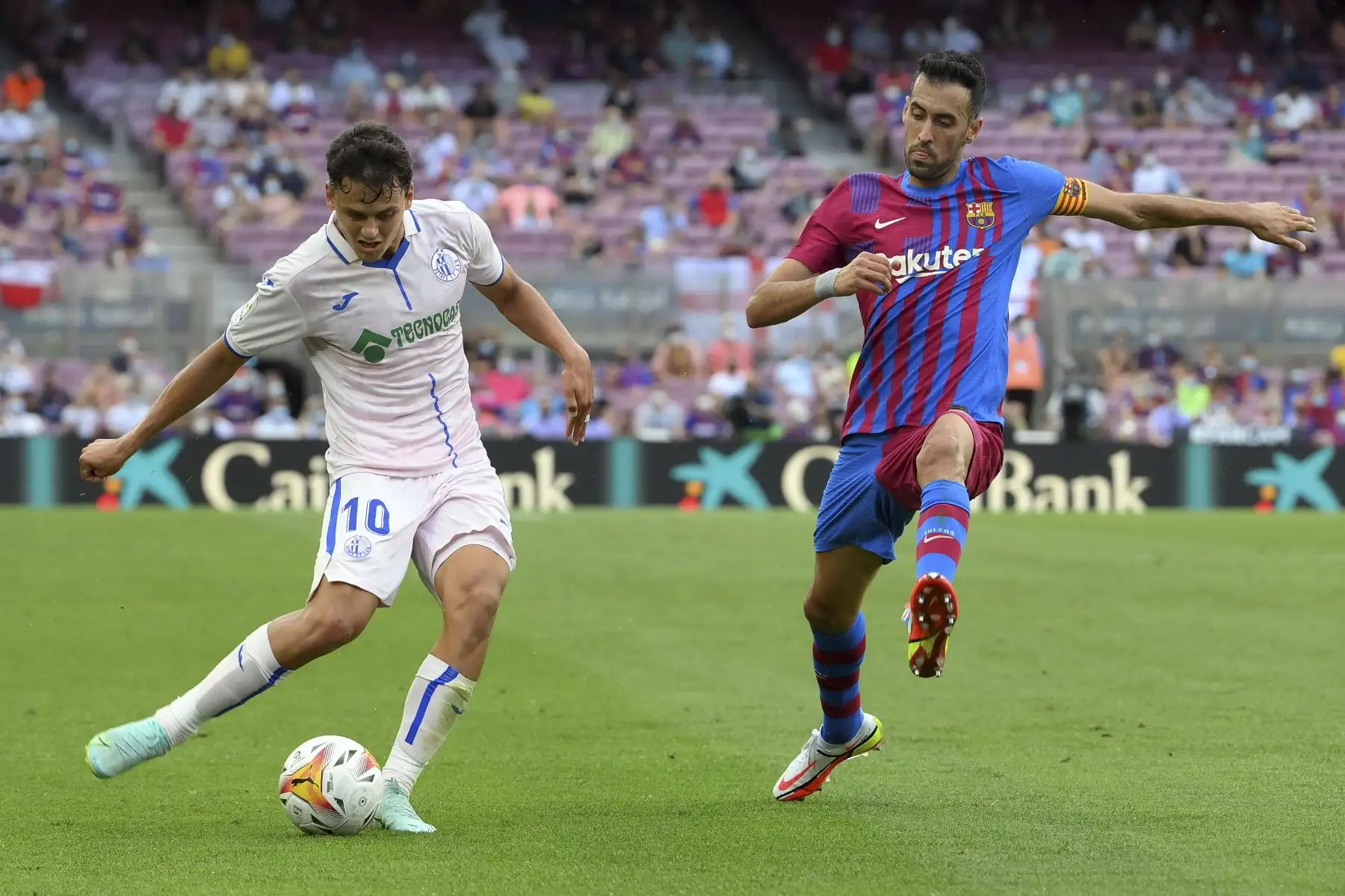 El delantero turco del Getafe, Enes Unal, controla el balón ante la marca del centrocampista español del Barcelona Sergio Busquets durante el partido de la Liga española. Foto: EFE
