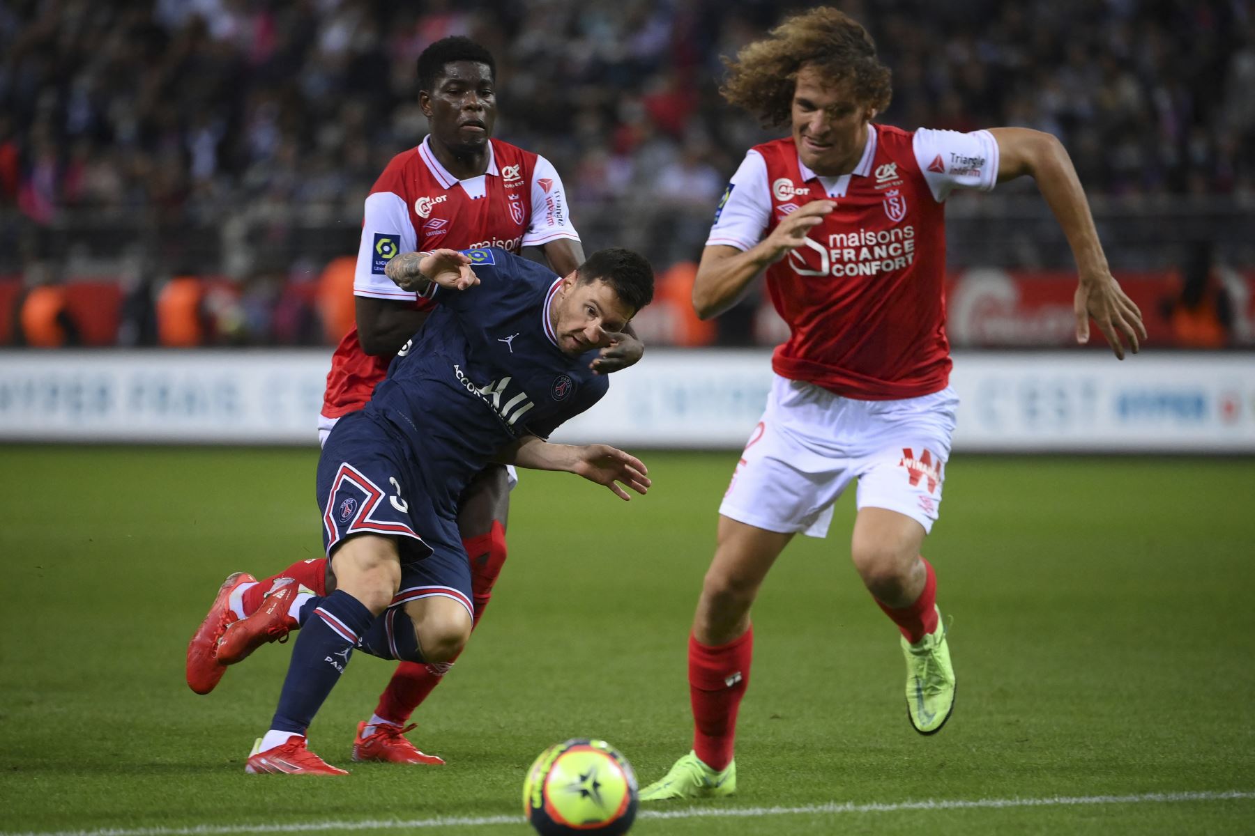 El delantero argentino del Paris Saint-Germain Lionel Messi (2L) es desafiado por el centrocampista zimbabuense de Reims Marshall Munetsi (L) y el defensor belga de Reims Wout Faes durante el partido de fútbol francés L1 entre el Stade de Reims y el Paris Saint-Germain (PSG) en el Stade. Foto:AFP