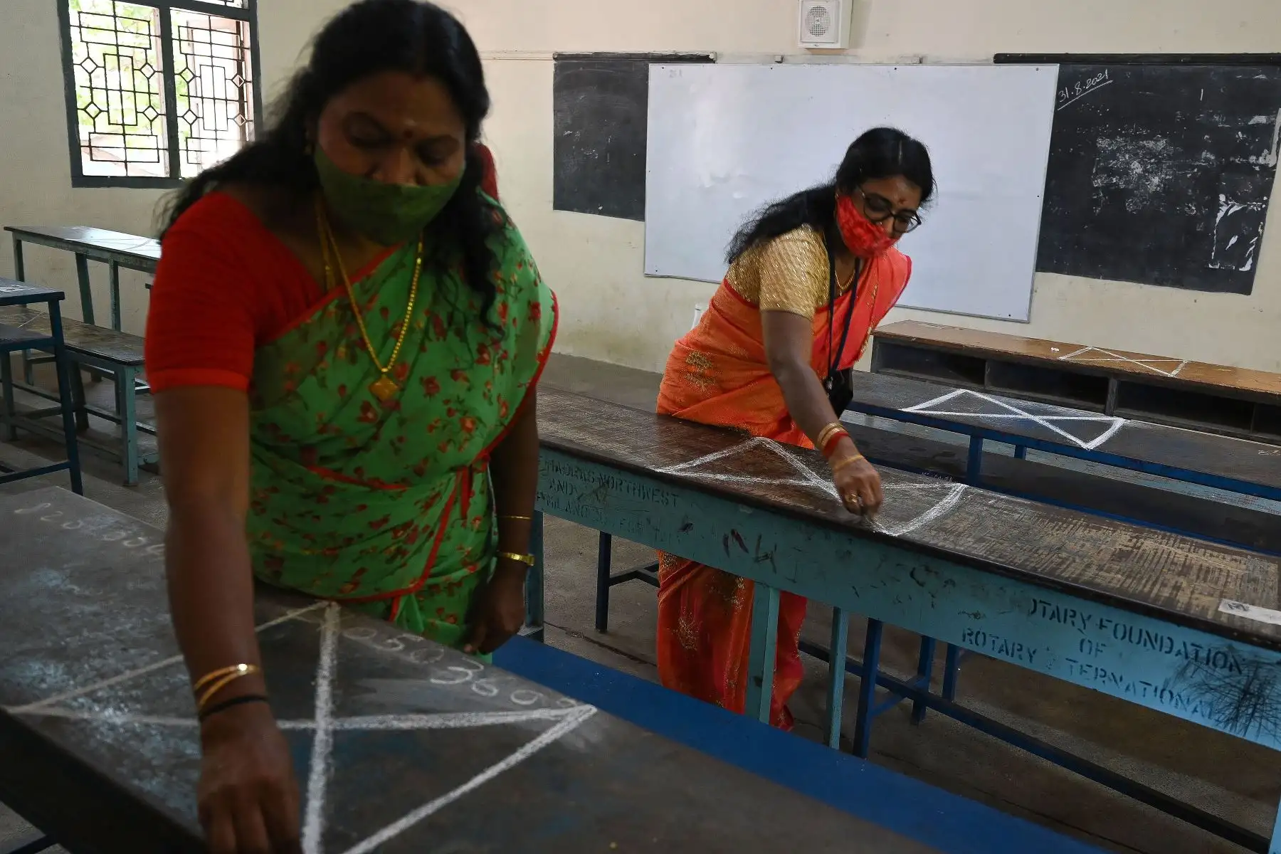 Los maestros hacen marcadores de distanciamiento social en los bancos de las aulas de una escuela mientras se preparan para la reapertura después de la relajación del bloqueo del covid-19 en Chennai.
Foto: AFP