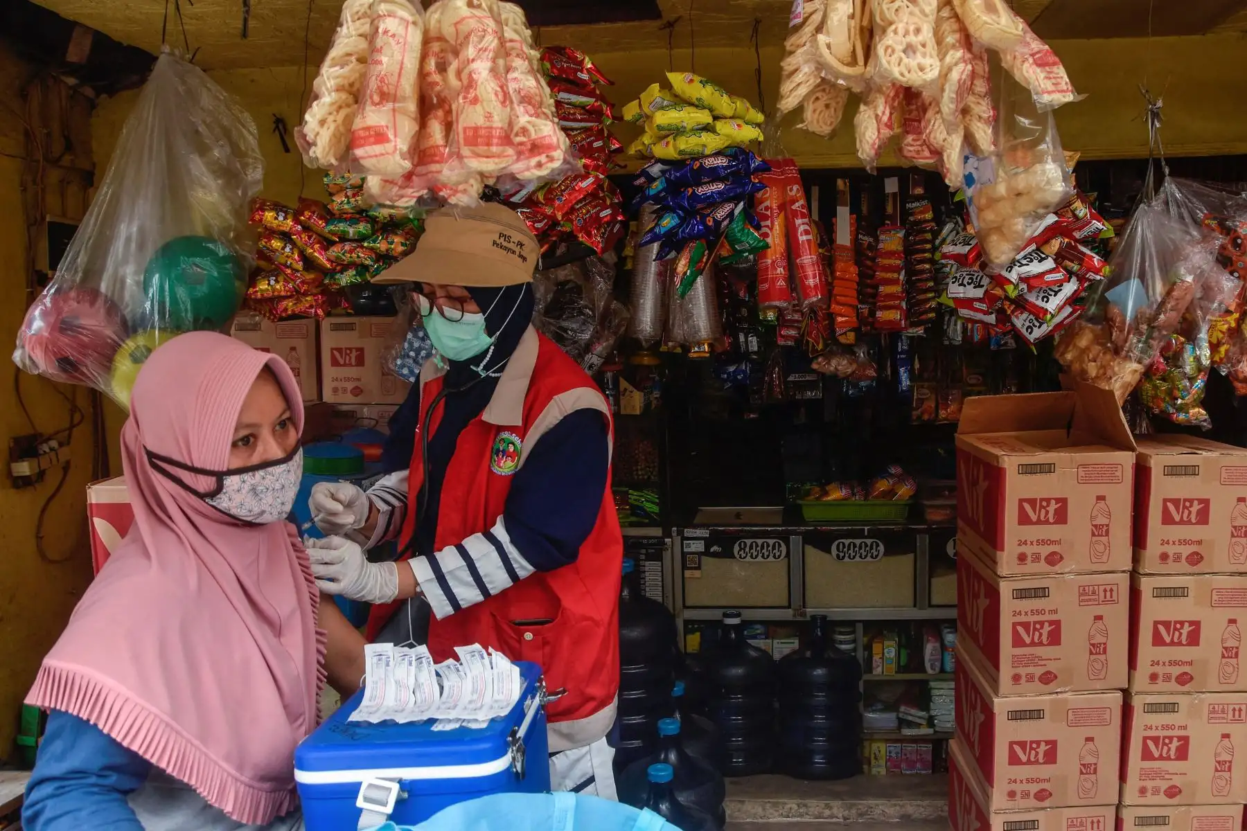 Una mujer recibe una inyección de la vacuna Pfizer covid-19 mientras los trabajadores médicos realizan vacunas puerta a puerta en Bekasi.
Foto: AFP