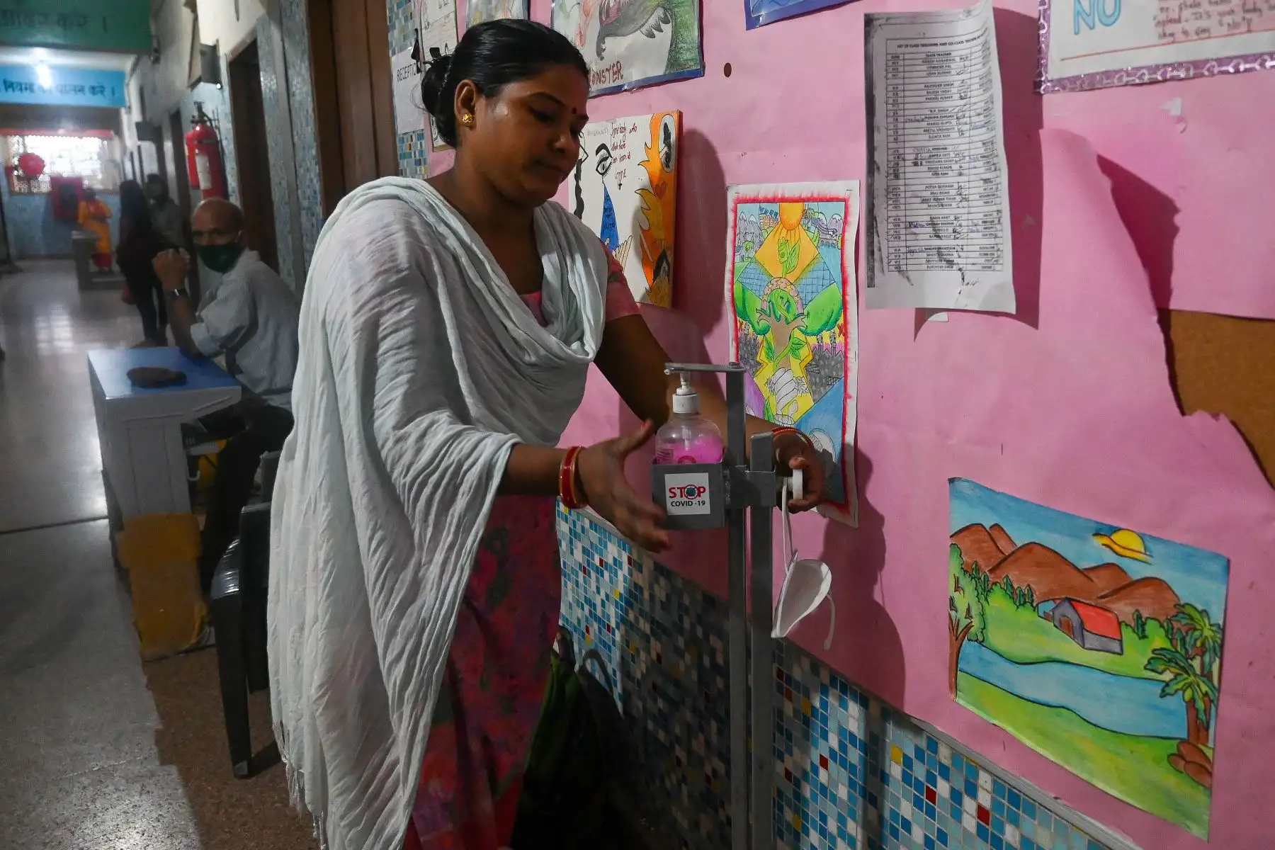 Un empleado de la escuela mantiene una botella de desinfectante de manos fuera de un aula en la escuela secundaria superior Sarvodyar en Nueva Delhi.
Foto: AFP