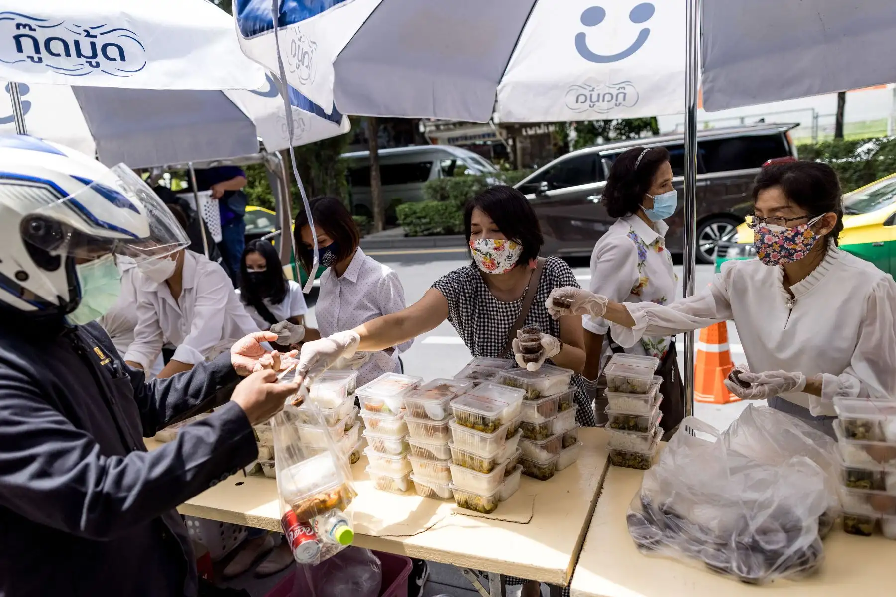 Los voluntarios que apoyan a los trabajadores locales durante la pandemia, entregan paquetes de comida y bebida en Bangkok, antes de la relajación de algunas de las restricciones del coronavirus en Tailandia.
Foto: AFP