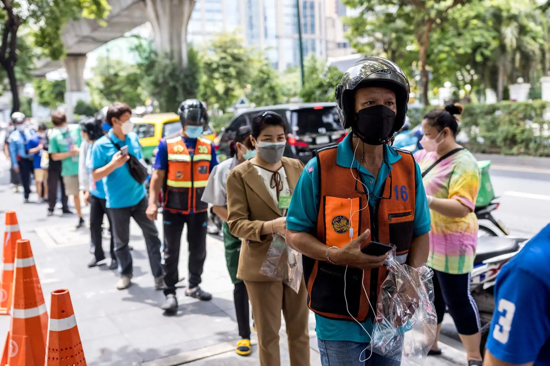 Un conductor de taxi en motocicleta hace cola para recibir un paquete de comida y bebida de voluntarios que apoyan a los trabajadores locales en Bangkok, antes de la relajación de algunas de las restricciones del coronavirus en Tailandia.
Foto: AFP
