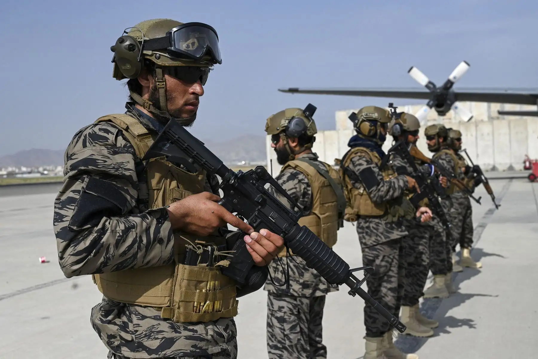 Miembros de la unidad militar talibán Badri 313 montan guardia junto a un avión de la Fuerza Aérea afgana en el aeropuerto de Kabul, después de que Estados Unidos retirara todas sus tropas del país.
Foto: AFP