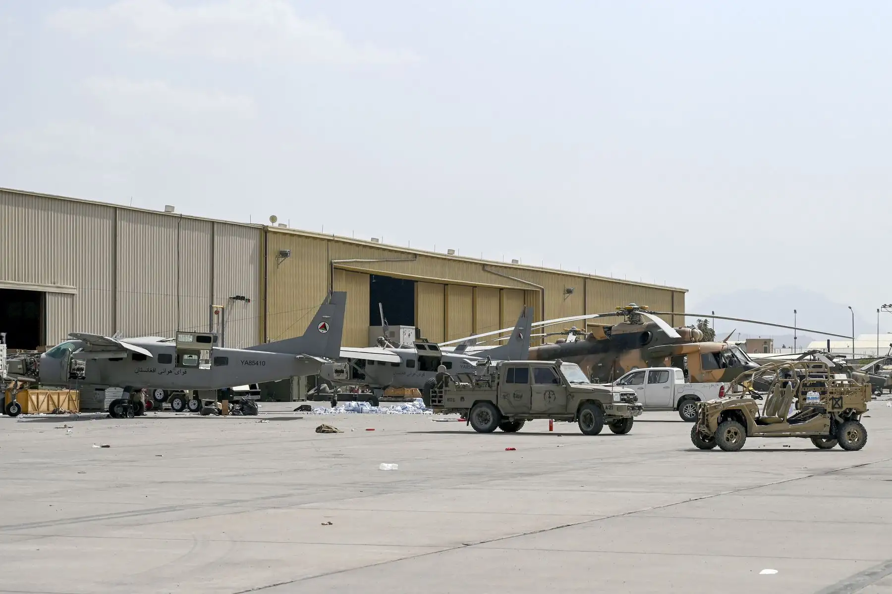 Las aeronaves y vehículos militares de las fuerzas aéreas afganas se muestran cerca de un hangar en el aeropuerto de Kabul, después de que Estados Unidos retirara a todas sus tropas del país.
Foto: AFP