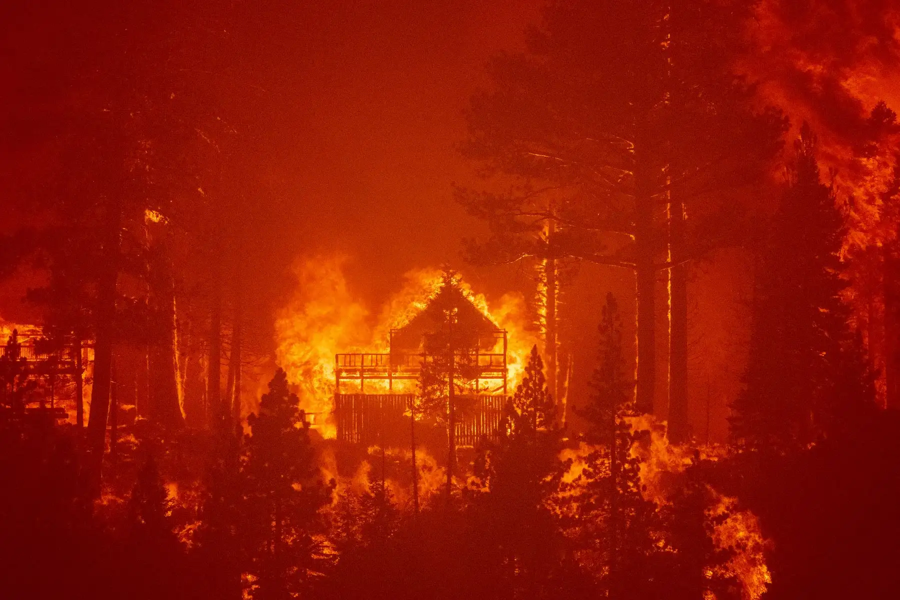 Las llamas consumen por completo varias casas a medida que el incendio de Caldor avanza hacia el área de Echo Summit, California, en los Estados Unidos. Foto: AFP