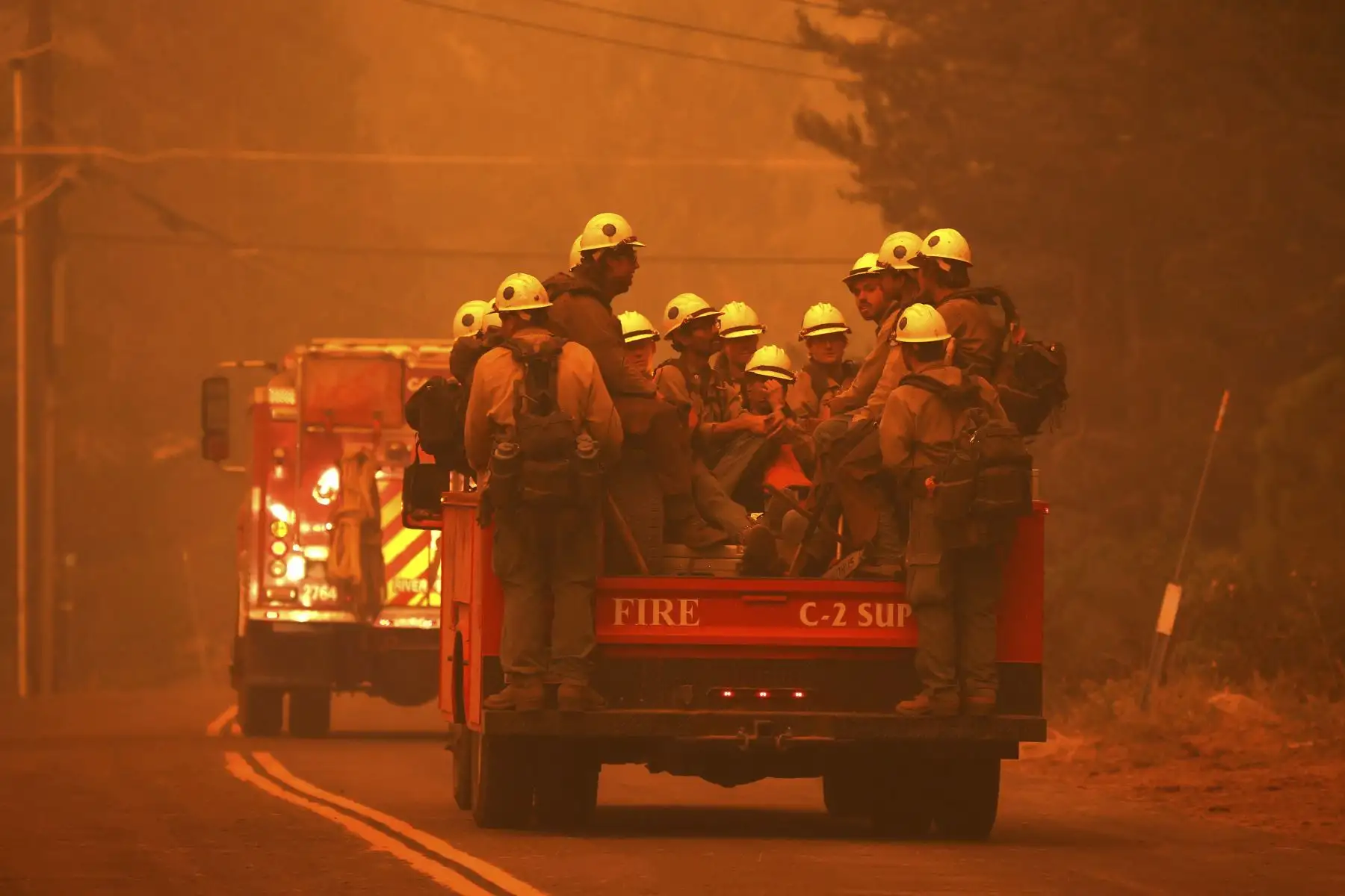 Los equipos de bomberos viajan en la parte trasera de un camión mientras se preparan para combatir el incendio Caldor, en South Lake Tahoe, California, Estados Unidos. Foto: AFP