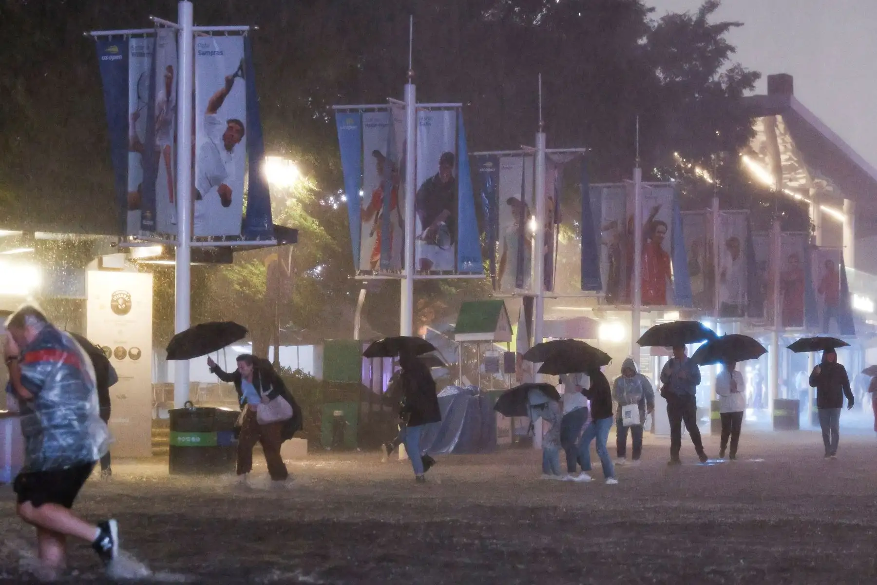 Personas caminan a través de fuertes lluvias y pasillos inundados en el Centro Nacional de Tenis Billie Jean King cuando los restos del huracán Ida azotaron la zona de Flushing Meadows, Nueva York, Estados Unidos. Foto: EFE