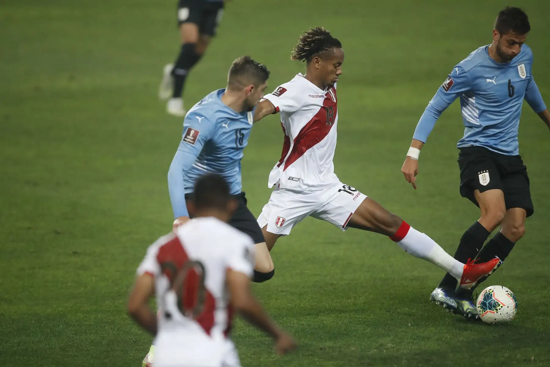 El jugador peruano André Carrillo disputa el balón ante el jugador de la selección uruguaya  durante el partido 
por la jornada 9 de las Eliminatorias Catar 2022 Estadio Nacional en Lima.
Foto: ANDINA/Juan Carlos Guzmán