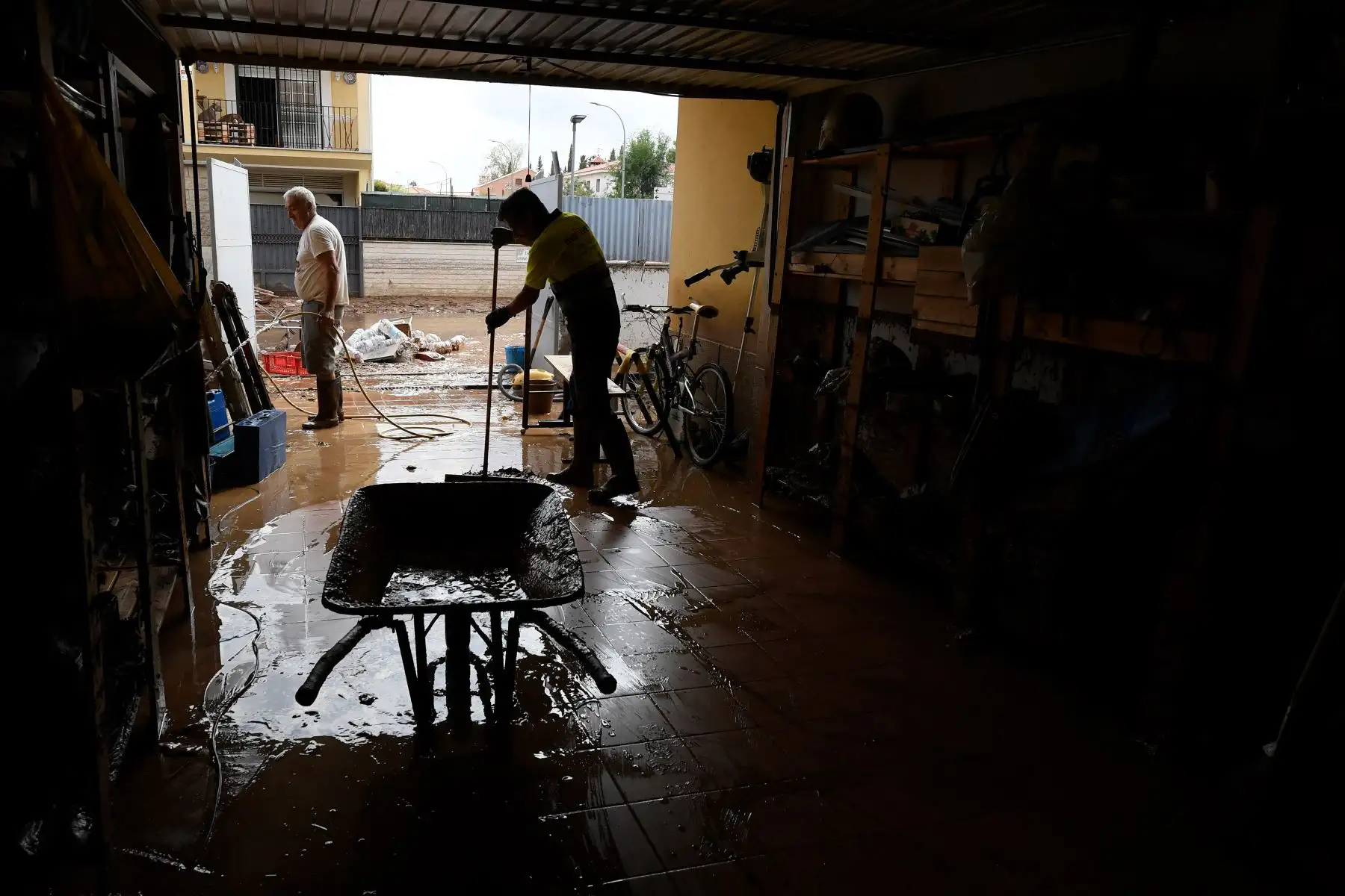 Los residentes limpian el garaje de una casa en Cobisa, provincia de Toledo, un día después que una inundación repentina afectara la zona. Foto: AFP