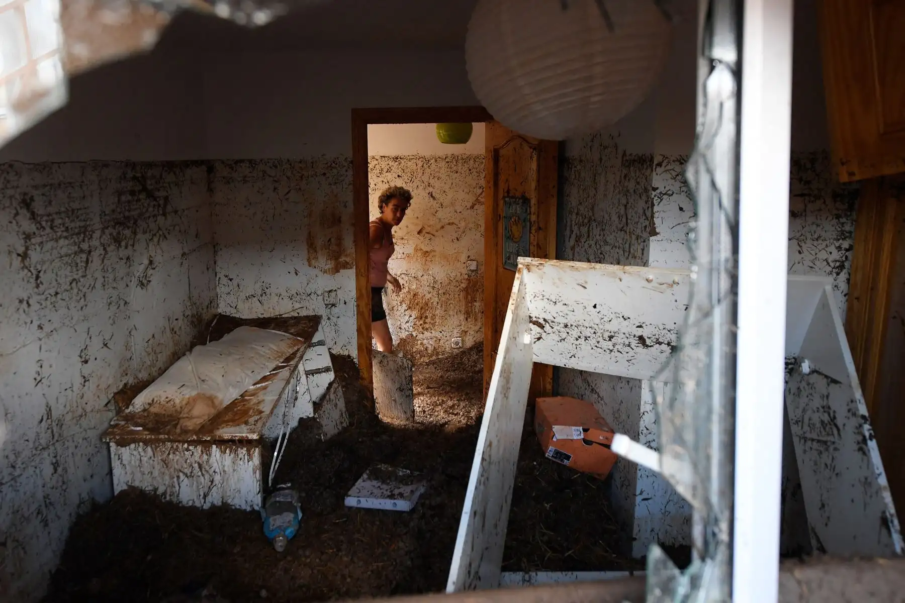 Una mujer camina en su casa en Cobisa, provincia de Toledo, España, un día después que una inundación repentina afectara la zona. Foto: AFP