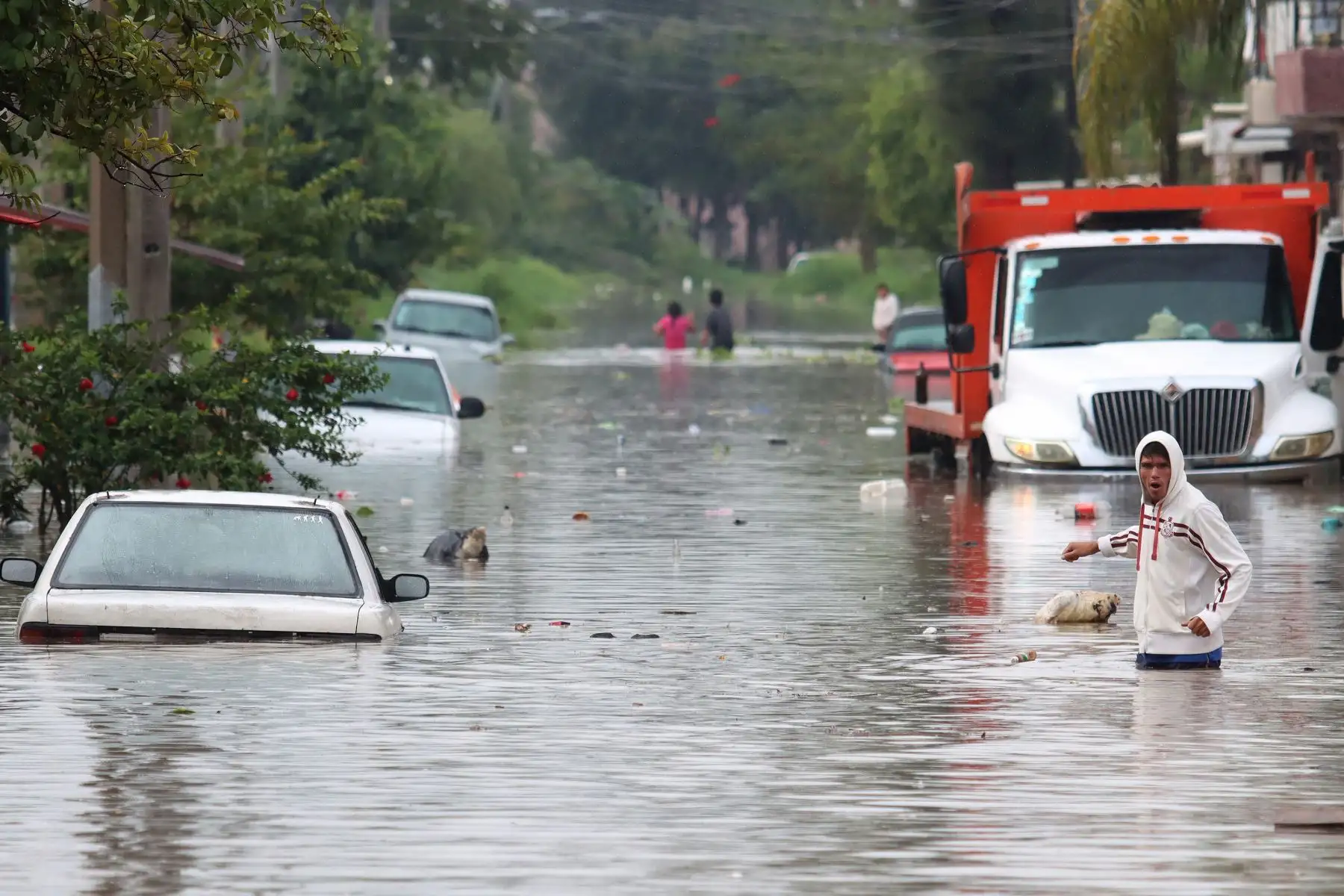La gente camina por una calle inundada después de las fuertes lluvias en Tlaquepaque, estado de Jalisco, México. Foto: AFP