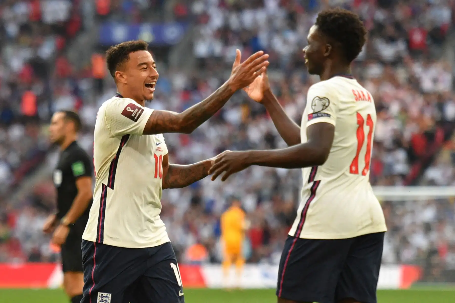 El centrocampista de Inglaterra Jesse Lingard celebra con su compañero Bukayo Saka después de anotar el tercer gol durante el partido de clasificación para la Copa Mundial Qatar 2022, en el estadio de Wembley, en Londres. Foto: AFP