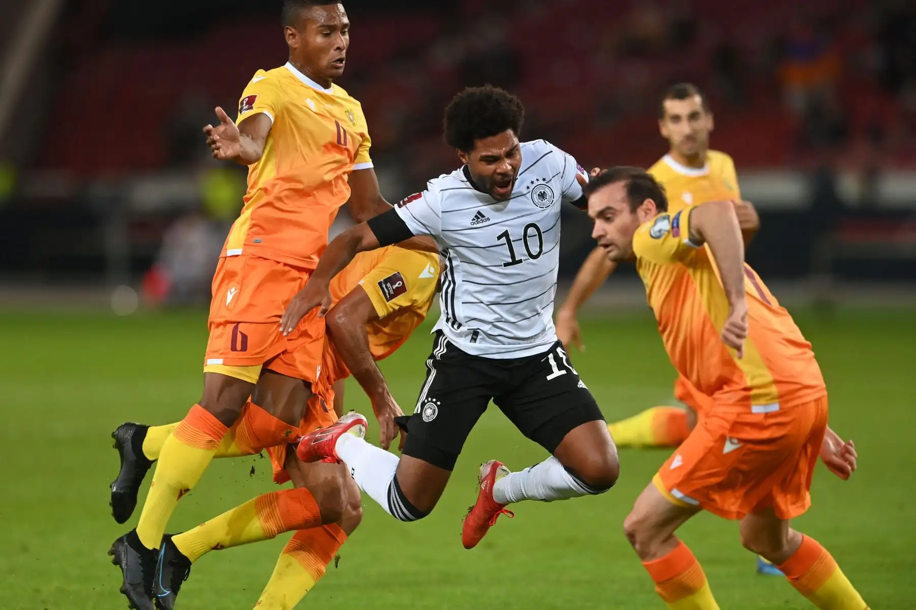 El centrocampista de Alemania Serge Gnabry compite con el centrocampist Wbeymar Angulo Mosquera y Kamo Hovhannisyan de Armenia durante el partido de clasificación de la Copa Mundial Qatar 2022. Foto: AFP