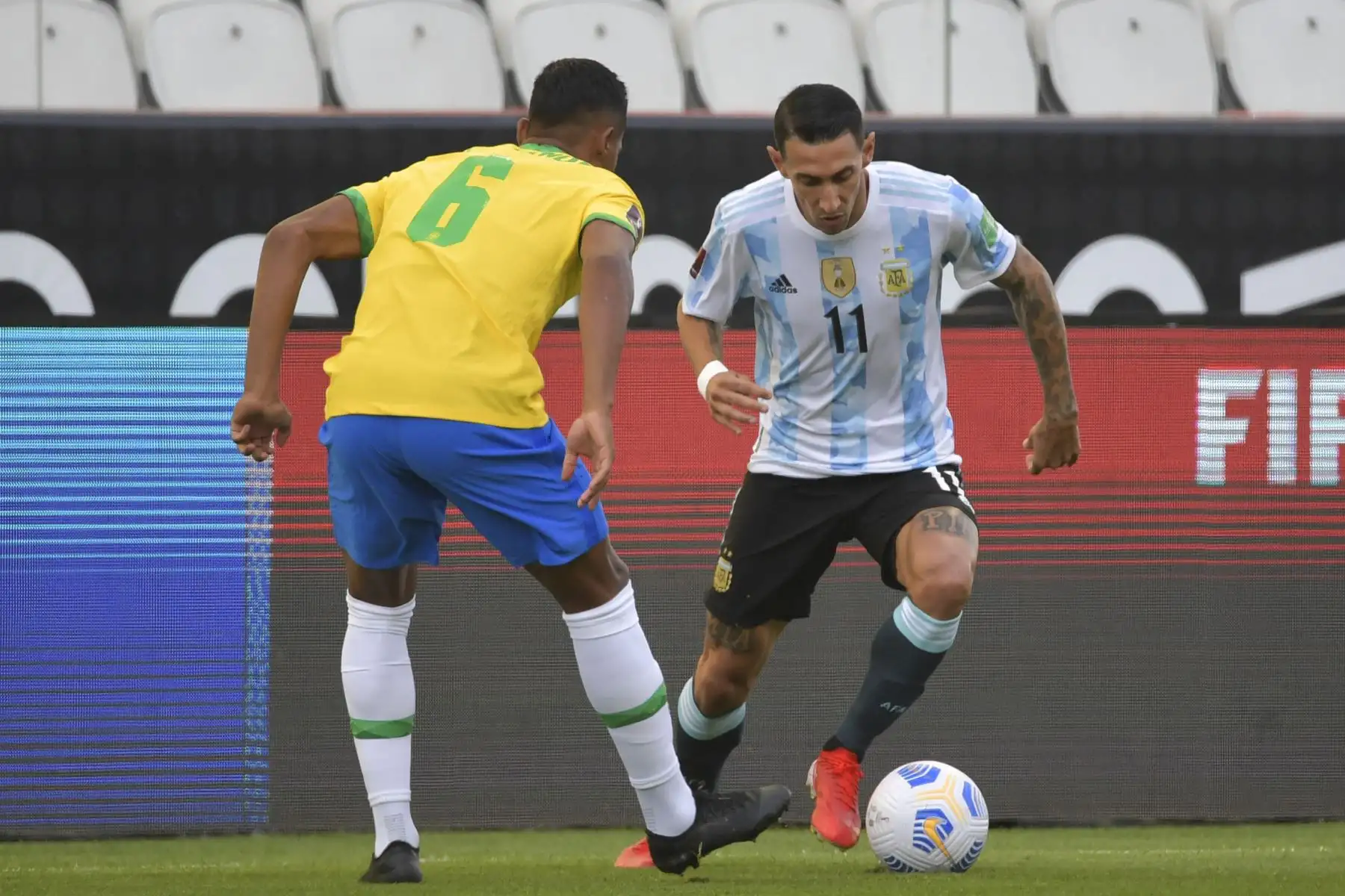 El argentino Angel Di Maria y el brasileño Alex Sandro compiten por el balón durante partido de clasificación para la Copa Mundial Qatar 2022, en Sao Paulo, Brasil. Foto: AFP