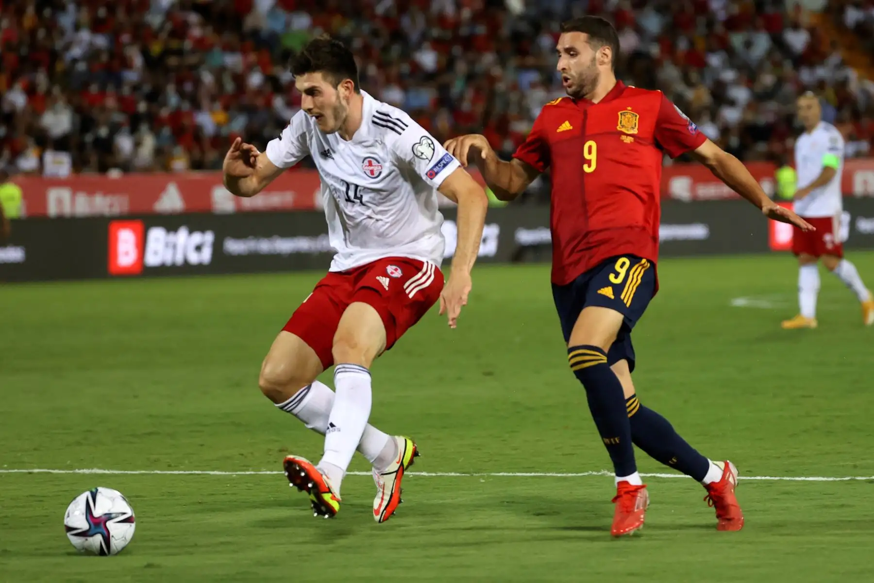 El defensa de Georgia Luka Lochoshvili protege el balón ante Abel Ruiz, de España, durante el partido clasificatorio al Mundial Catar 2022. Foto: EFE