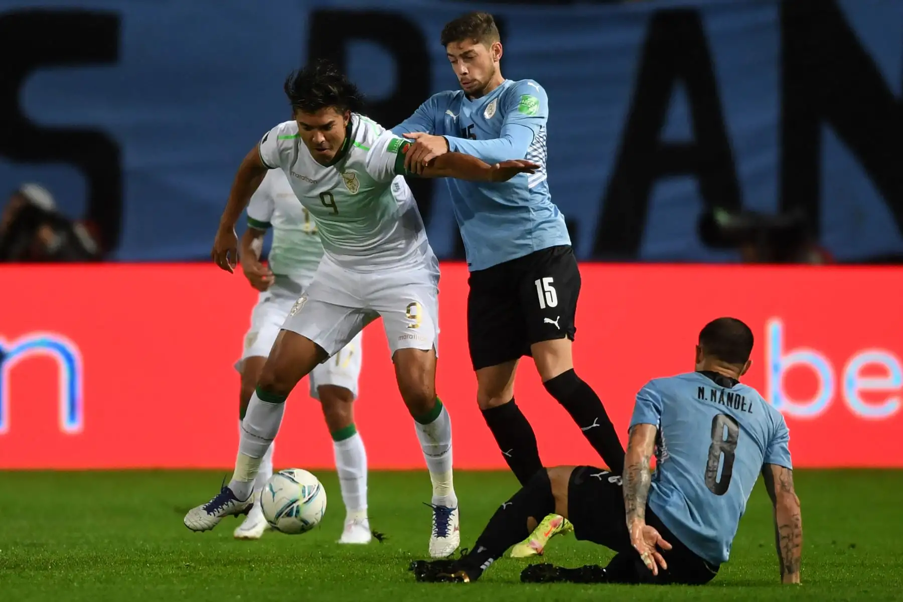 El boliviano Marcelo Martins (L) y el uruguayo Federico Valverde (C) compiten por el balón durante su partido de fútbol sudamericano de clasificación para la Copa Mundial de la FIFA Qatar 2022 en el Estadio Campeon del Siglo en Montevideo el 5 de septiembre de 2021. Foto: AFP