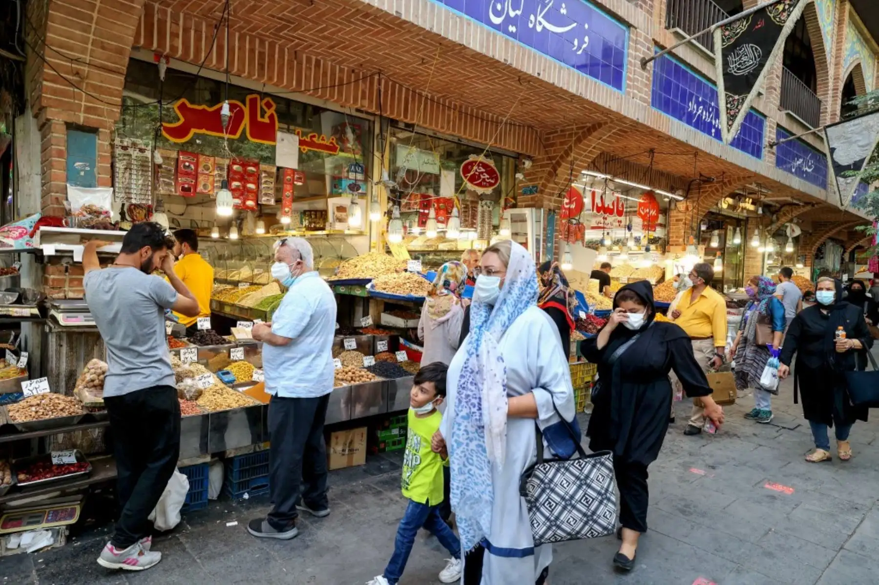 Los iraníes con máscaras faciales como protección contra el Covid-19, compran en el Gran Bazar de la capital de Irán, Teherán. Foto: AFP