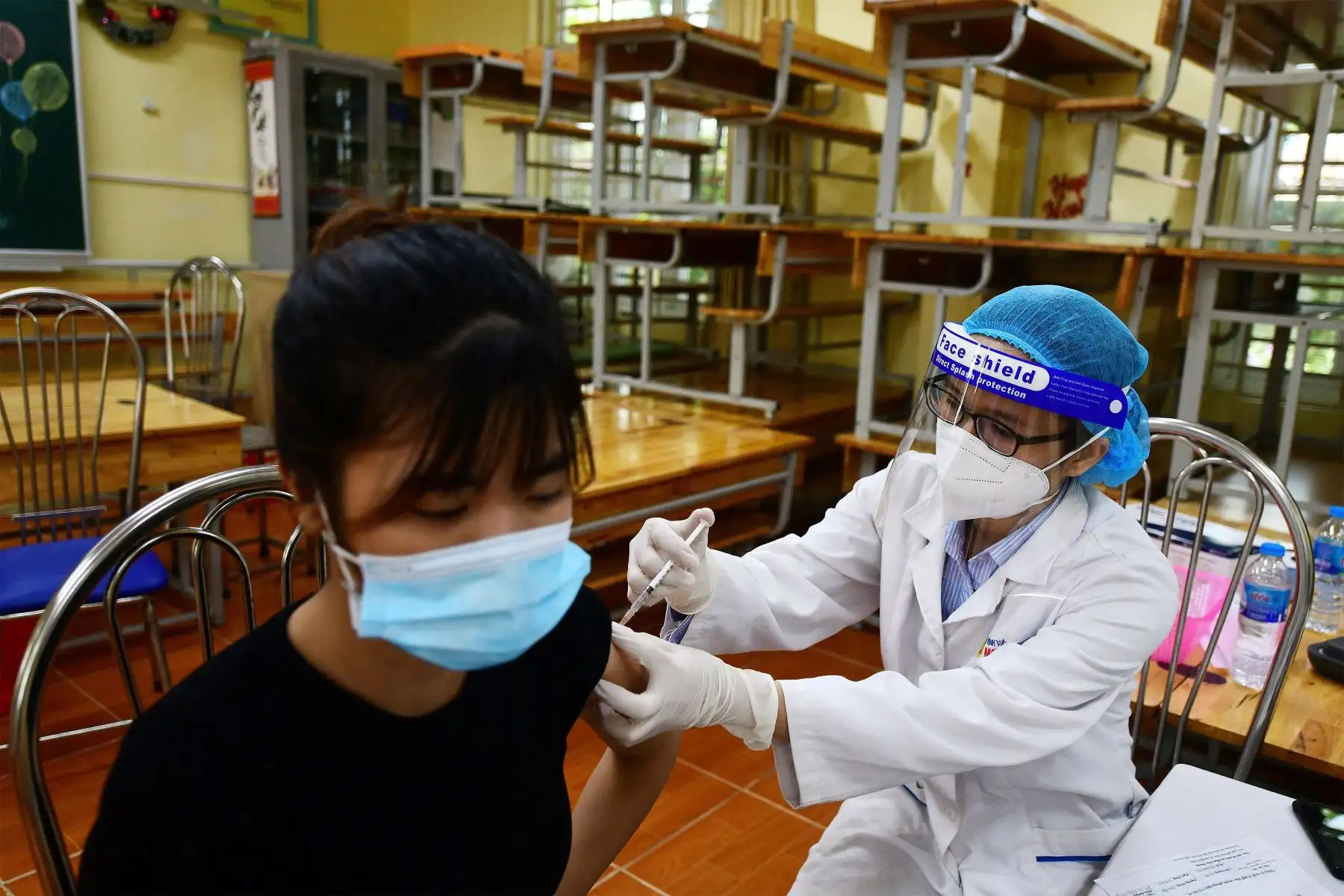 Una mujer recibe la vacuna contra el coronavirus  Covid-19 dentro de un aula vacía en Hanoi.
Foto: AFP