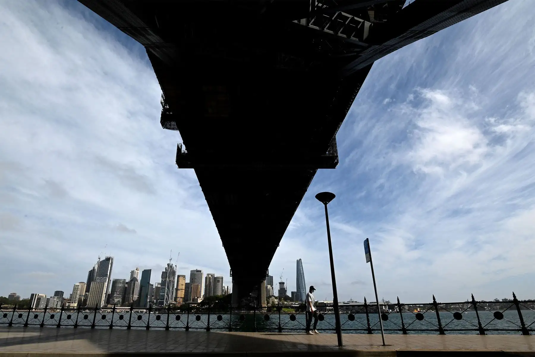 Un hombre camina por el puerto de Sydney, ya que el estado de Nueva Gales del Sur registró 1542 nuevos casos de covid-19 adquiridos localmente y nueve muertes en las últimas 24 horas.
Foto: AFP