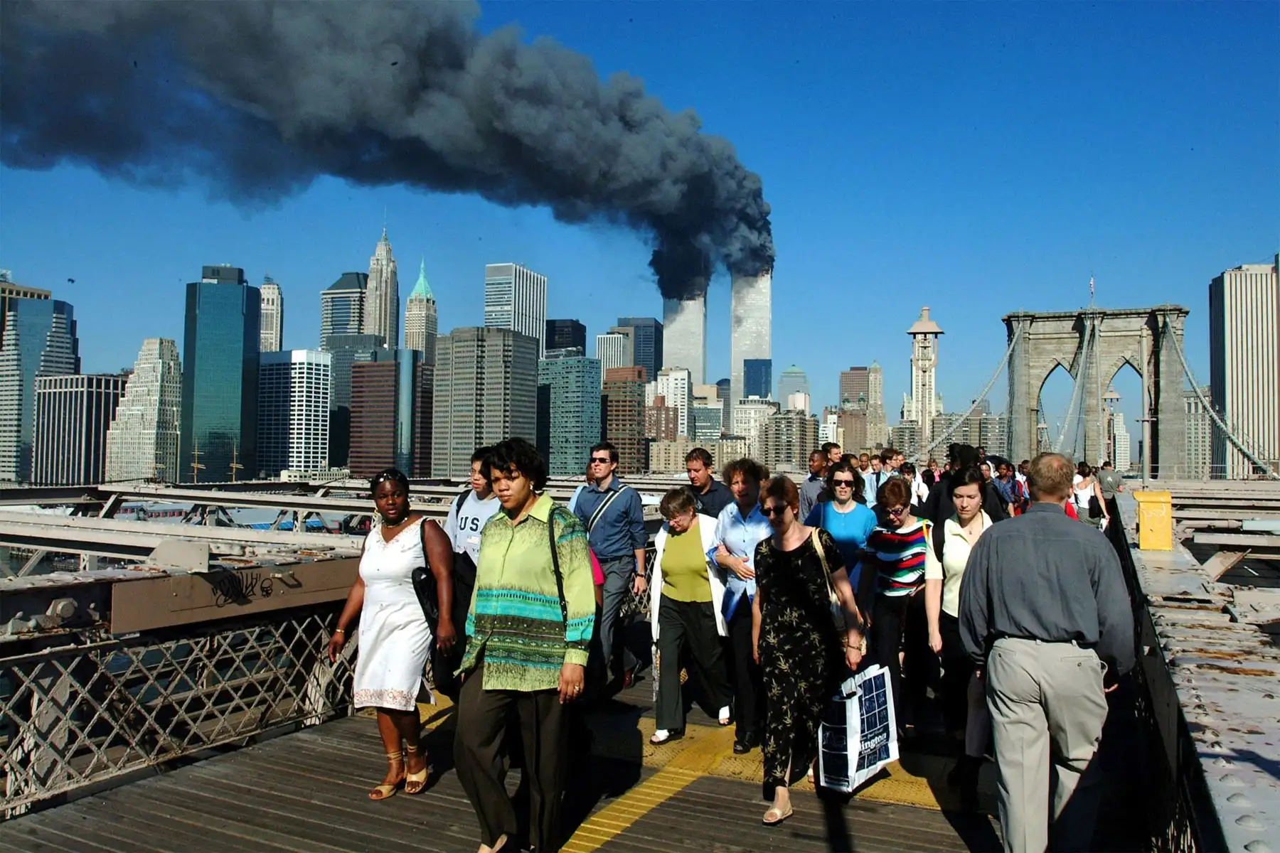 Los peatones cruzan el Puente de Brooklyn alejándose de las torres de World Trade en llamas antes de su derrumbe el 11 de septiembre de 2001. Ambas torres fueron alcanzadas por aviones de pasajeros secuestrados en un  ataque terrorista. Ambas torres colapsaron más tarde. 
Foto: AFP Los peatones cruzan el Puente de Brooklyn alejándose de las torres de World Trade en llamas antes de su derrumbe el 11 de septiembre de 2001. Ambas torres fueron alcanzadas por aviones de pasajeros secuestrados en un  ataque terrorista. Ambas torres colapsaron más tarde. 
Foto: AFP