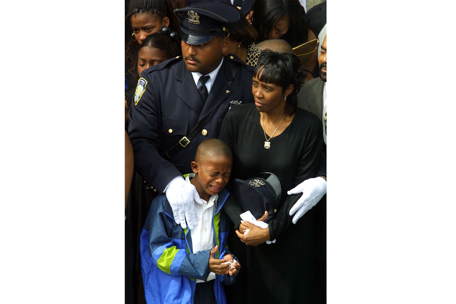 Daphne Davis está rodeada de familiares y amigos durante el funeral de su esposo, Clinton Davis Sr., oficial del Departamento de Policía de la Autoridad Portuaria, el 27 de septiembre de 2001 en el vecindario de Flushing en Queens, Nueva York. 
Foto: AFP
