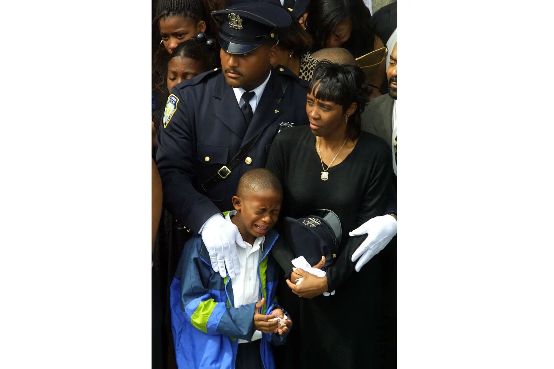 Daphne Davis está rodeada de familiares y amigos durante el funeral de su esposo, Clinton Davis Sr., oficial del Departamento de Policía de la Autoridad Portuaria, el 27 de septiembre de 2001 en el vecindario de Flushing en Queens, Nueva York. 
Foto: AFP Daphne Davis está rodeada de familiares y amigos durante el funeral de su esposo, Clinton Davis Sr., oficial del Departamento de Policía de la Autoridad Portuaria, el 27 de septiembre de 2001 en el vecindario de Flushing en Queens, Nueva York. 
Foto: AFP