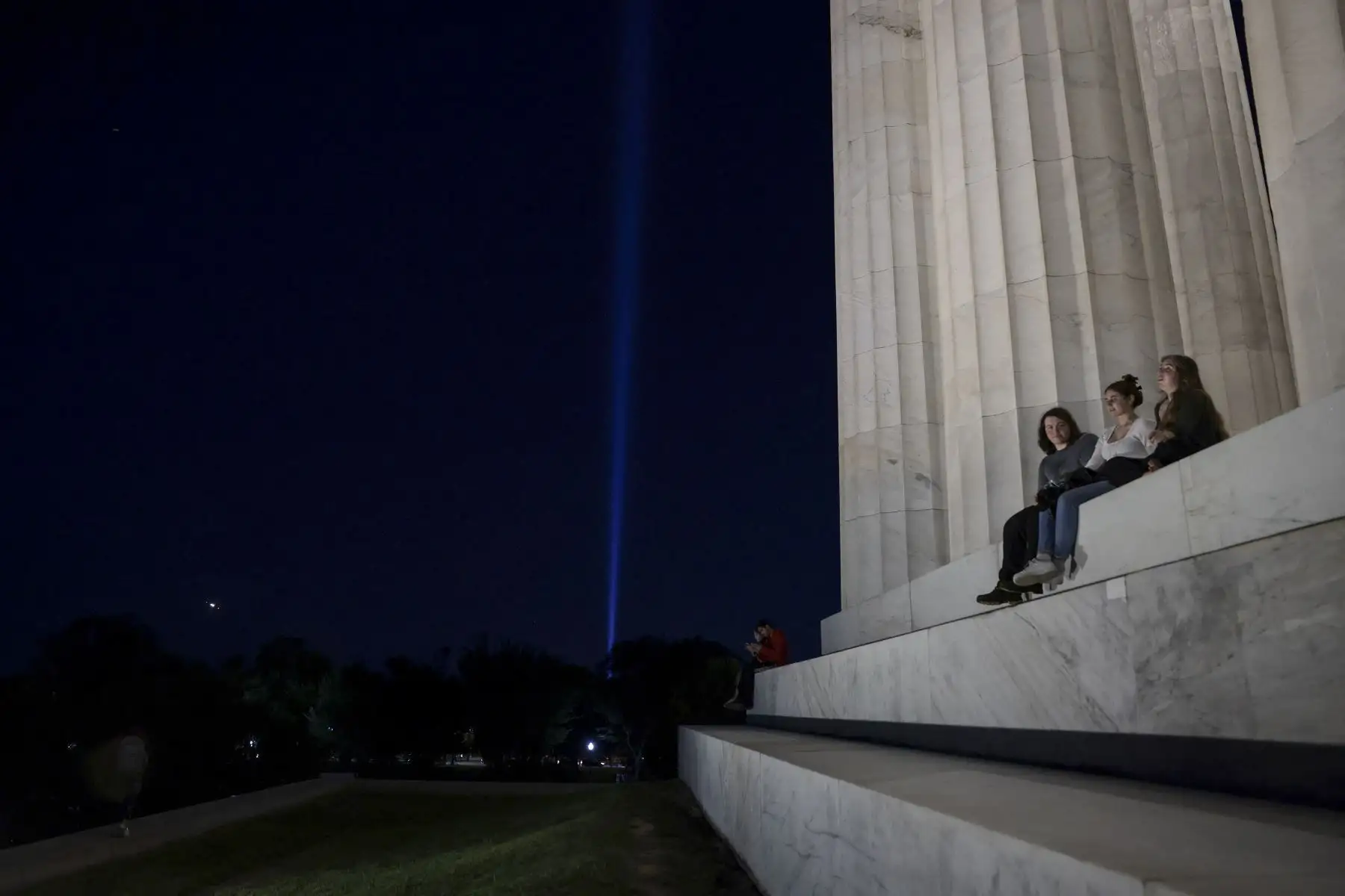 La gente se sienta en los escalones del Lincoln Memorial mientras el tributo a la 