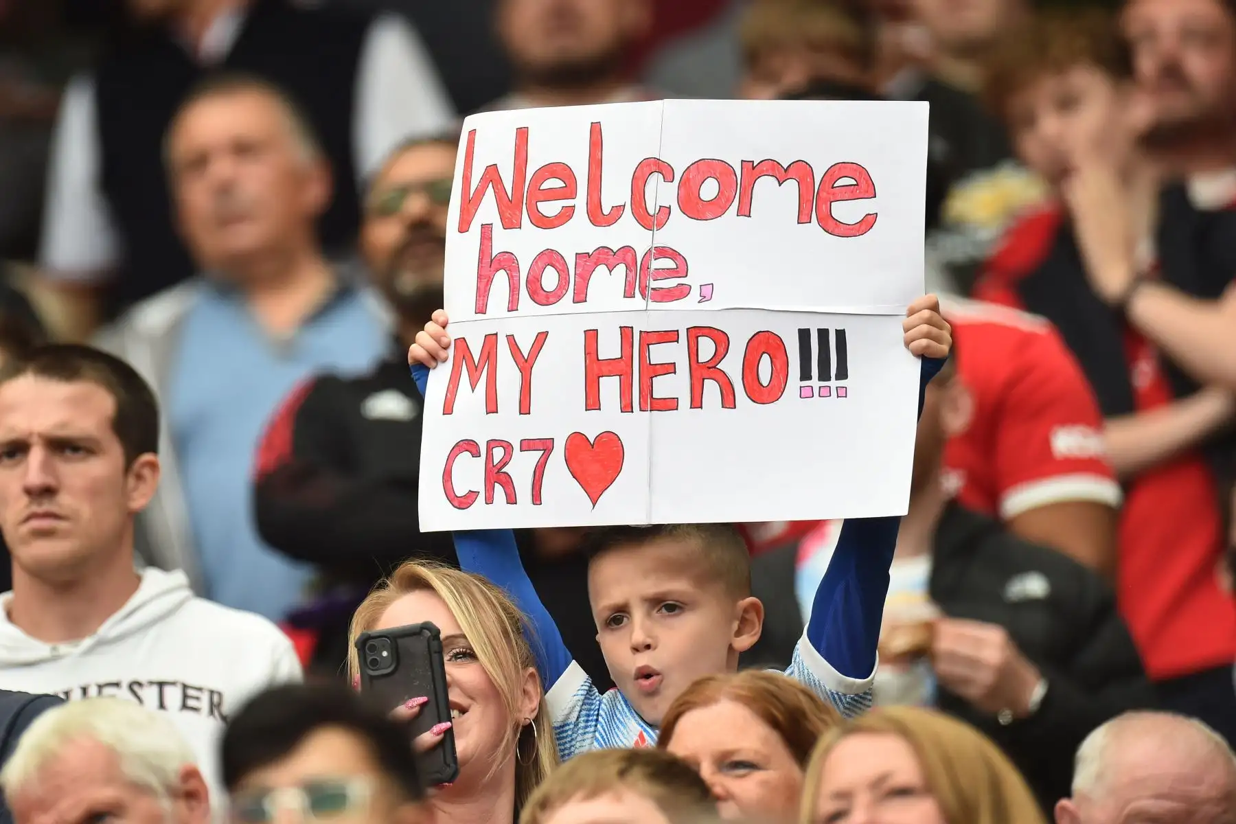 Un pequeño seguidor del Manchester United sostiene un cartel dedicado a Cristiano Ronaldo antes del partido ante Newcastle por la Premier League. Foto: EFE