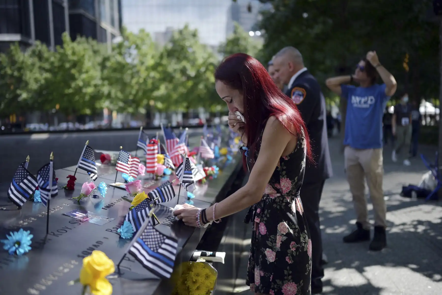 Una mujer cuyo padre murió el 11 de septiembre deposita flores en el Museo y Memorial Nacional 11-S, durante la ceremonia de conmemoración del 20 aniversario de los ataques terroristas al World Trade Center, en Nueva York. Foto: AFP