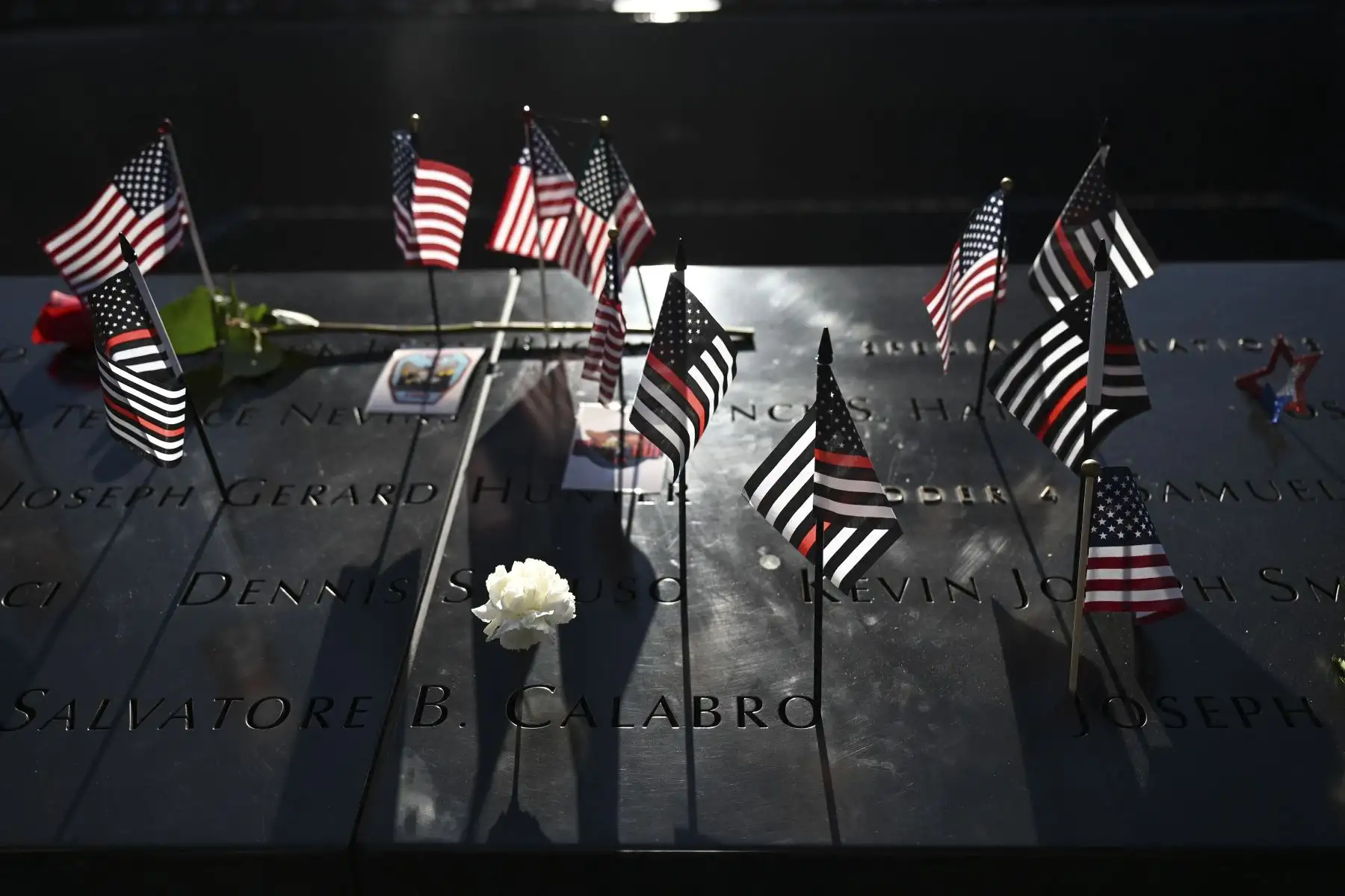 Se exhiben banderas y rosas durante una ceremonia en el Museo y Memorial Nacional del 11 de septiembre que conmemora el 20 aniversario de los ataques terroristas, en el World Trade Center, Nueva York. Foto: AFP