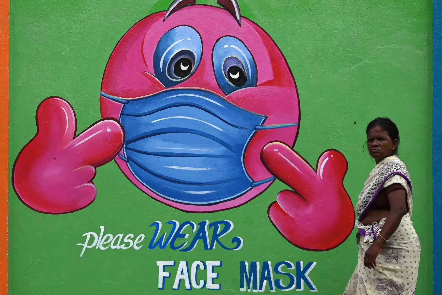 Una mujer pasa junto a un mural de concienciación sobre el coronavirus Covid-19 a lo largo de la carretera en Chennai.
Foto: AFP