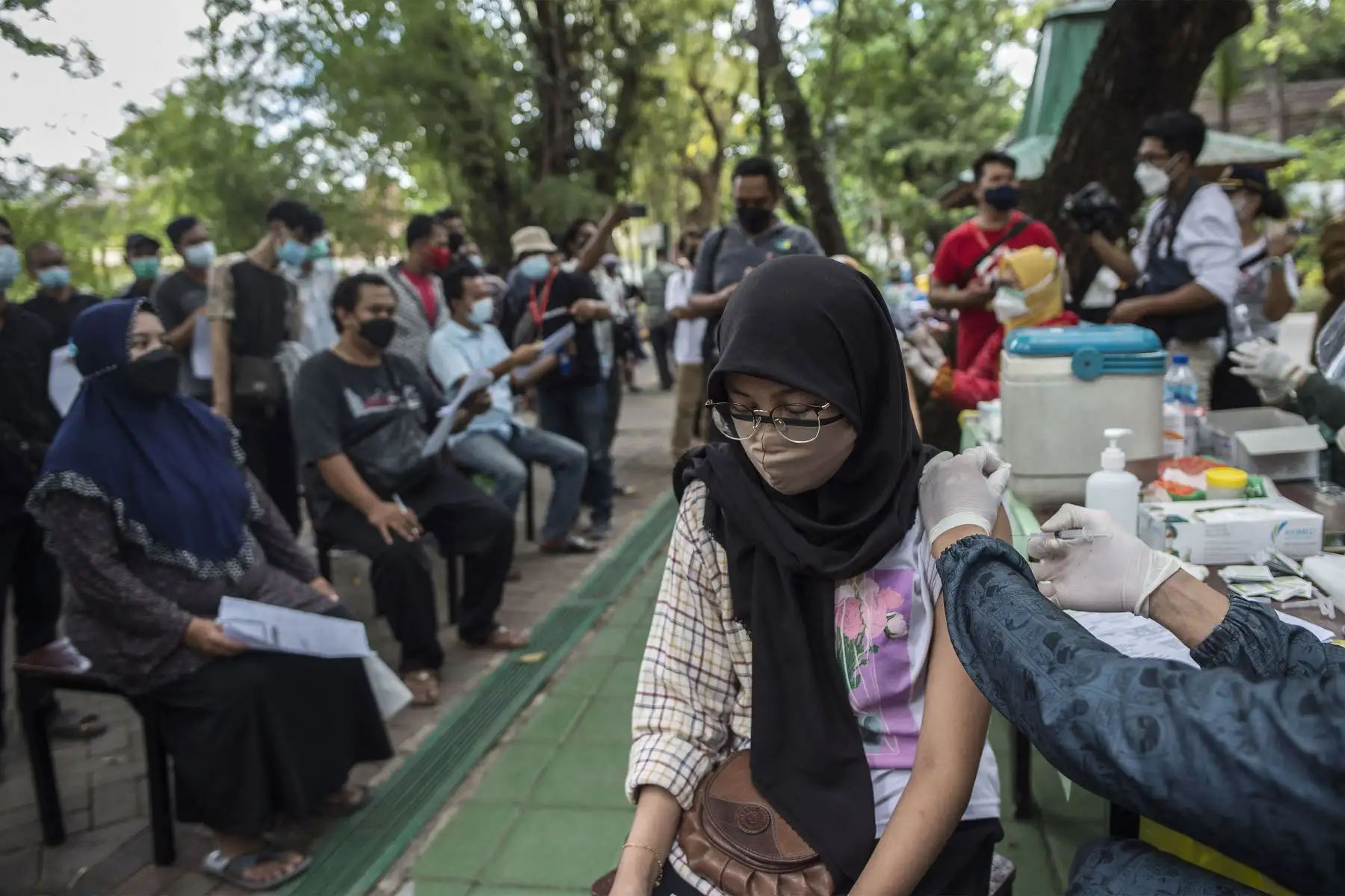 Un trabajador de la salud inocula a una mujer con una dosis de la vacuna Sinovac covid-19 durante una vacunación masiva en un zoológico de Surabaya.
Foto: AFP