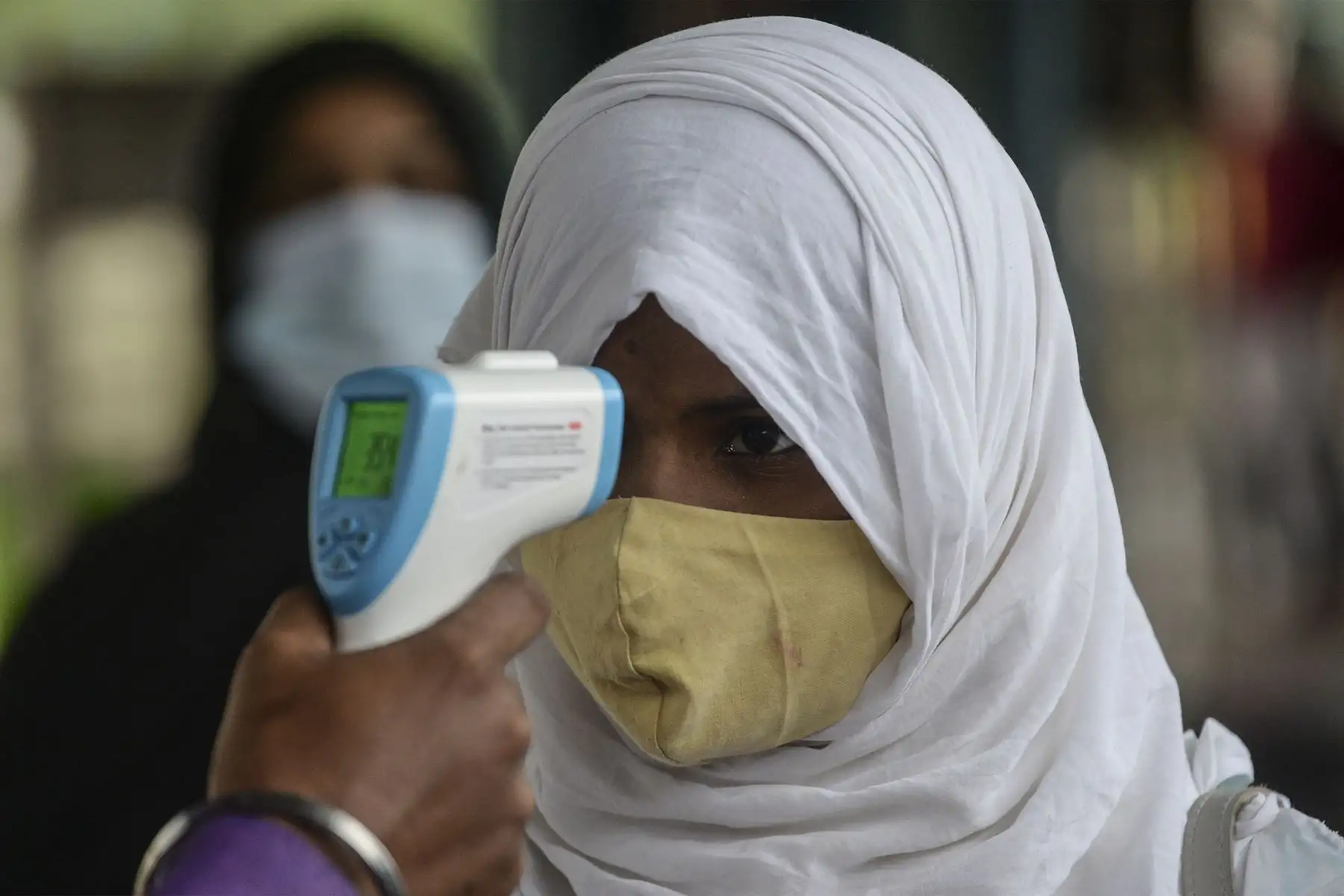 Un personal médico verifica la temperatura corporal de un pasajero a su llegada a una plataforma ferroviaria en Mumbai.
Foto: AFP