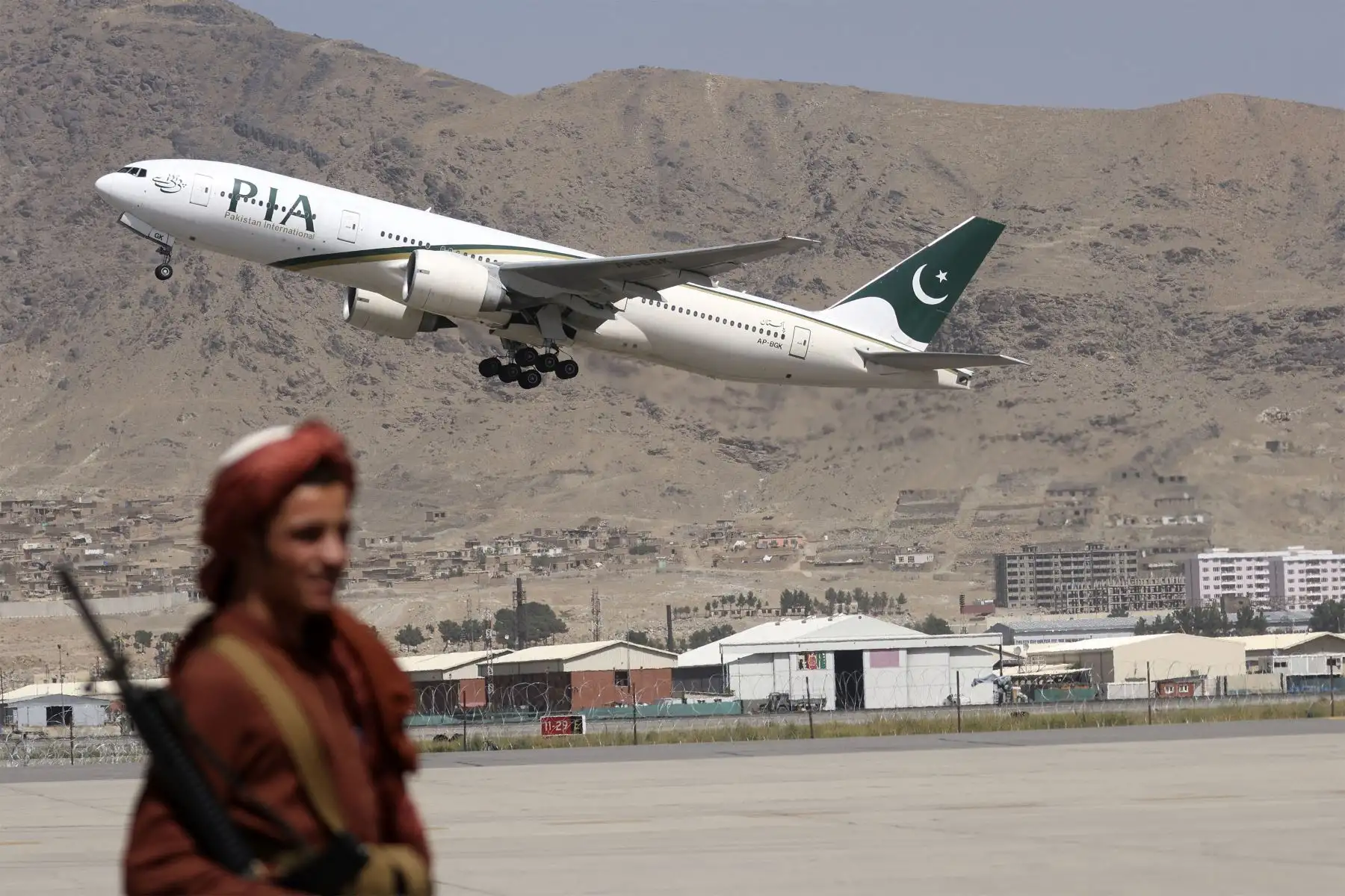 Un combatiente talibán hace guardia mientras un avión de Pakistan International Airlines, el primer vuelo comercial internacional en aterrizar desde que los talibanes recuperaron el poder el mes pasado, despega con pasajeros a bordo en el aeropuerto de Kabul.
Foto: AFP