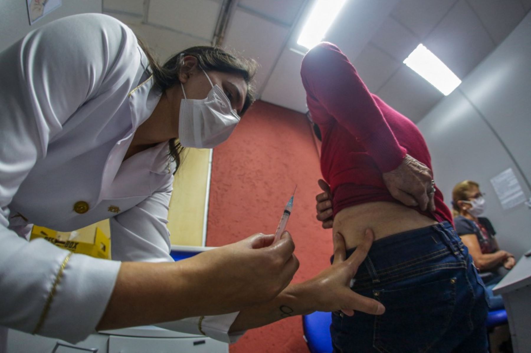 Una mujer recibe un pinchazo de la vacuna Pfizer-BioNtech covid-19 en el músculo ventroglúteo, en el Centro de Eventos de Cau Hansen, ubicado en la ciudad de Joinville, estado de Santa Catarina, Brasil. Foto: AFP