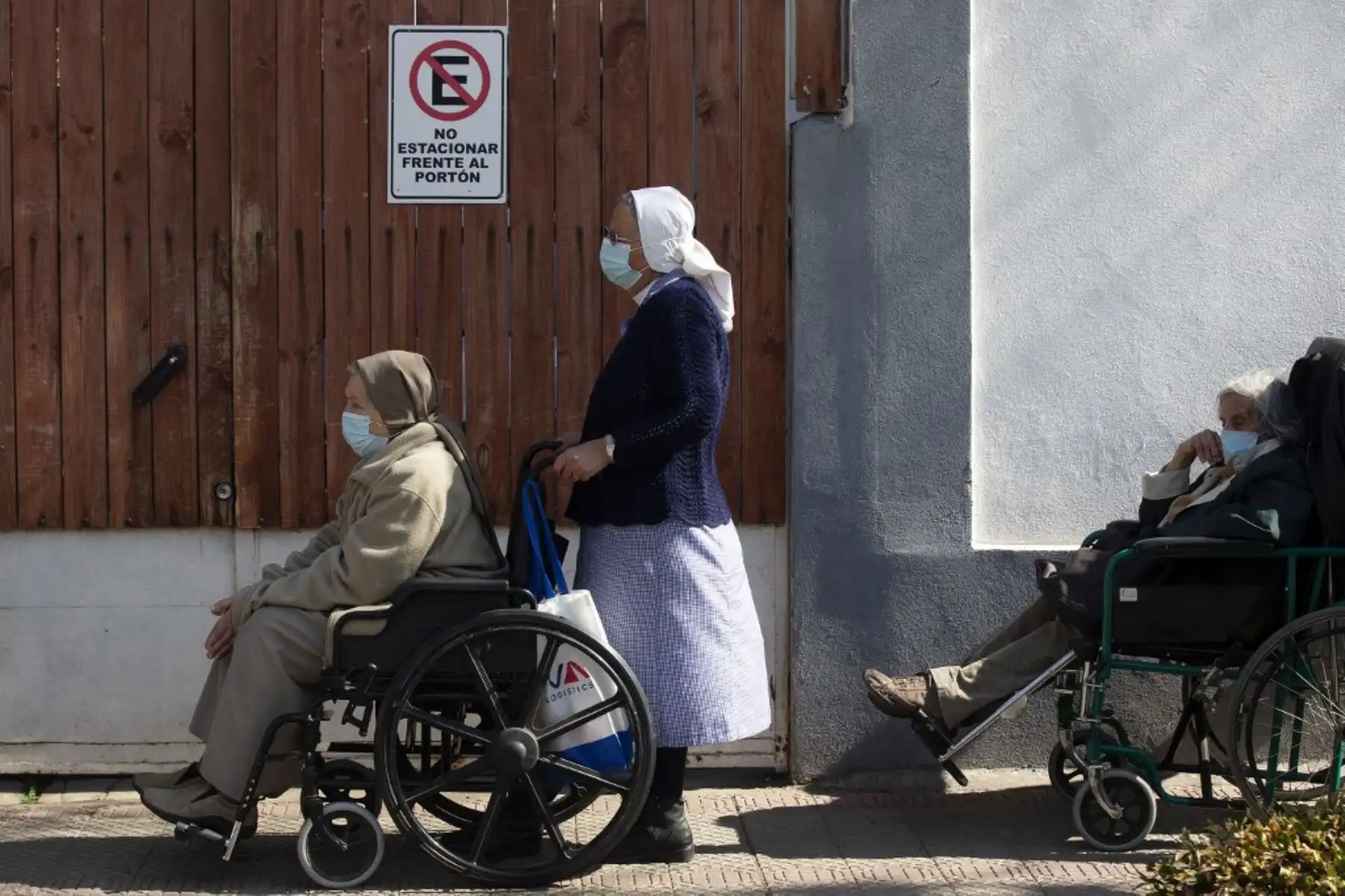 Ancianos hacen cola esperando su turno para recibir una tercera dosis de refuerzo de la vacuna Astrazeneca contra Covid-19 en un centro de vacunación de Santiago de Chile. Foto: AFP