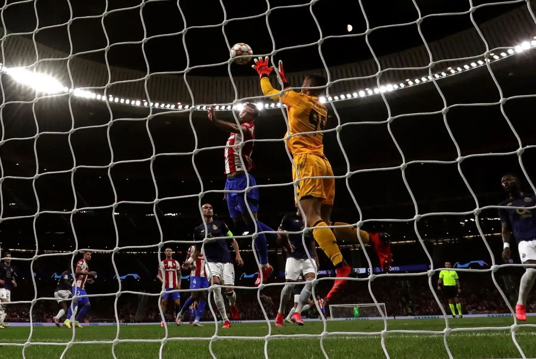 El portero del Oporto Diogo Costa detiene un balón ante Felipe Monteiro, del Atlético de Madrid, que disputan este miércoles en el Wanda Metropolitano. EFE/Juanjo Martín