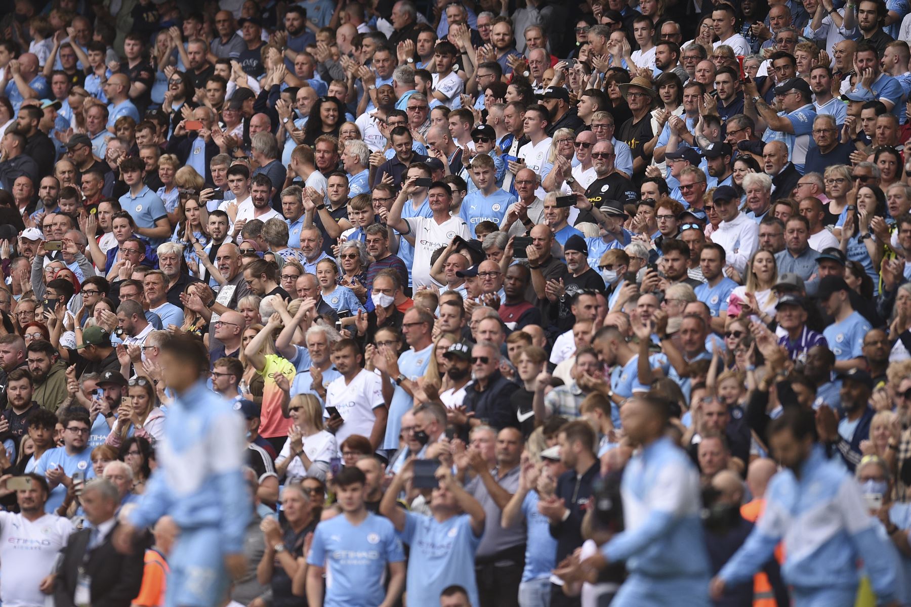 Los aficionados del Manchester City saludan a su equipo antes del partido de la Premier League. Foto: AFP